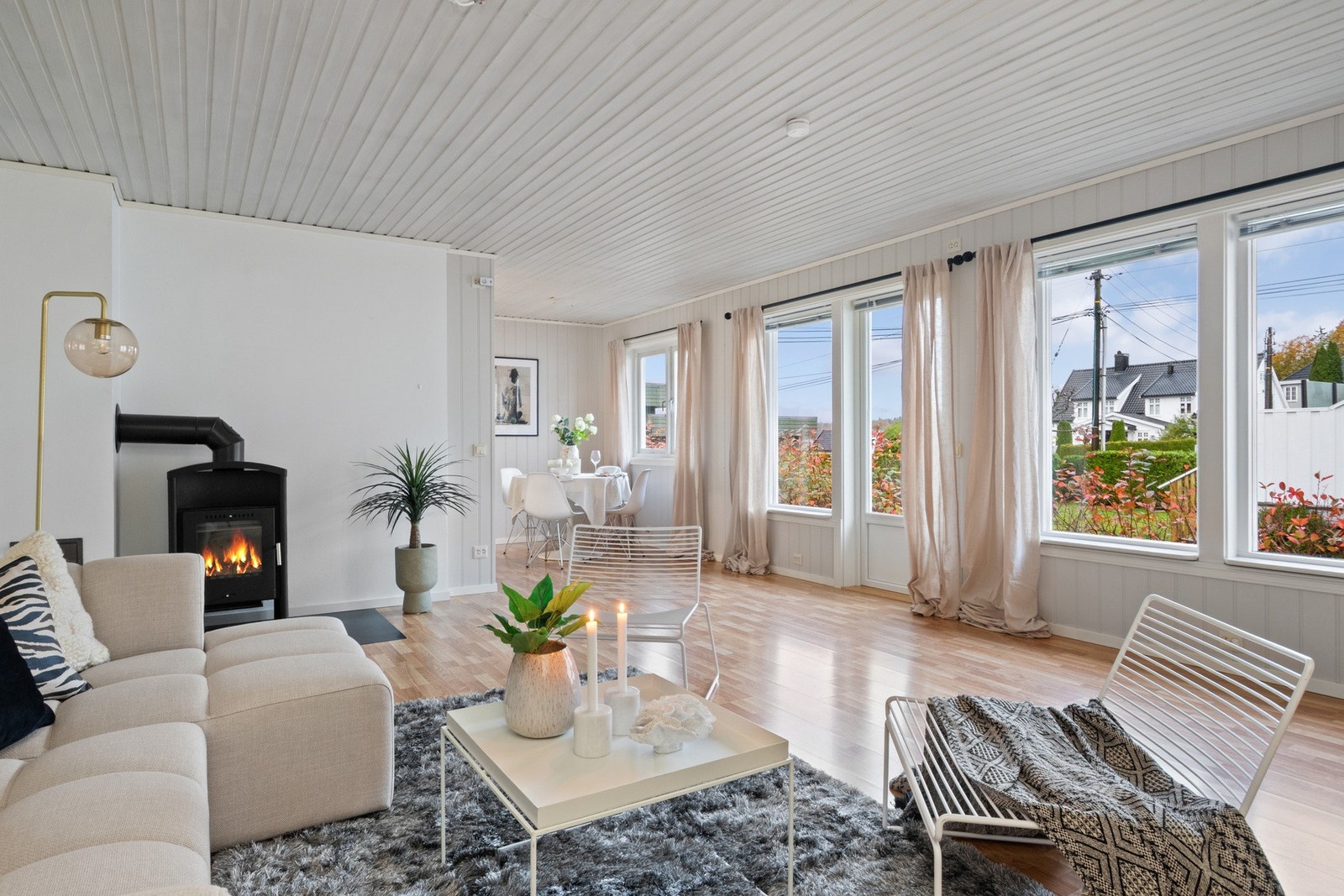 Lys og åpen stue med store vindusflater som slipper inn rikelig med dagslys og gir utsyn mot hagen. Galleribilde