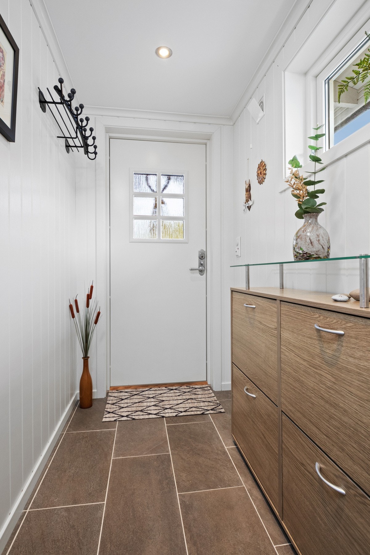 Lys og trivelig entré med praktiske fliser og god plass til å henge fra seg. Galleribilde
