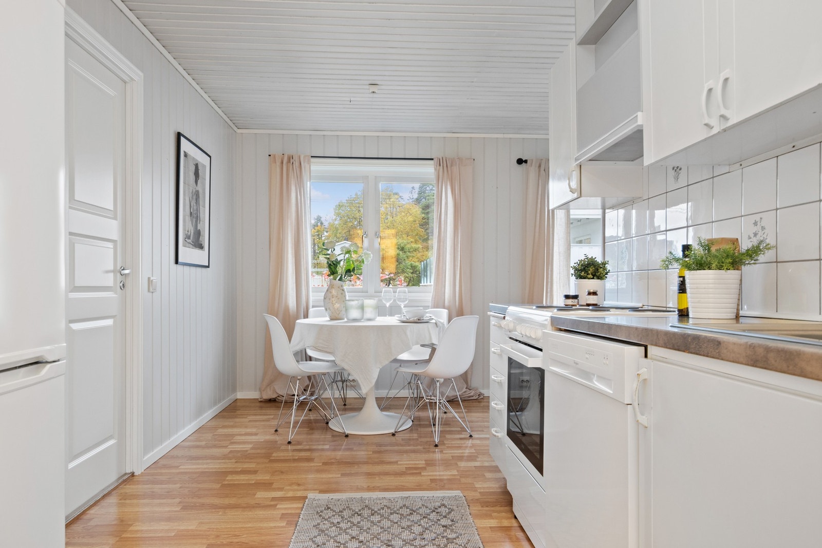 Trivelig kjøkken med spiseplass ved vinduet. Galleribilde