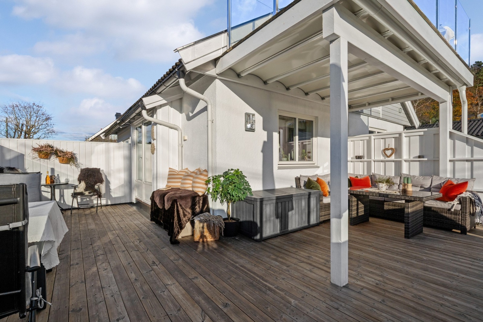 Terrassen strekker seg langs husveggen og kombinerer åpne og overbygde soner - her er det lett å finne en plass i solen. Galleribilde