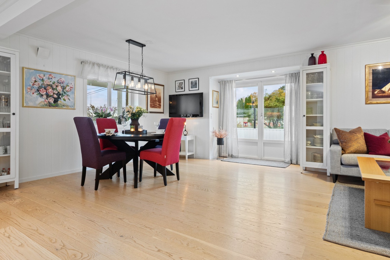 Stue og spiseplass i åpen løsning - her flyter rommene sømløst sammen, og ildstedet gir både varme og stemning. Galleribilde