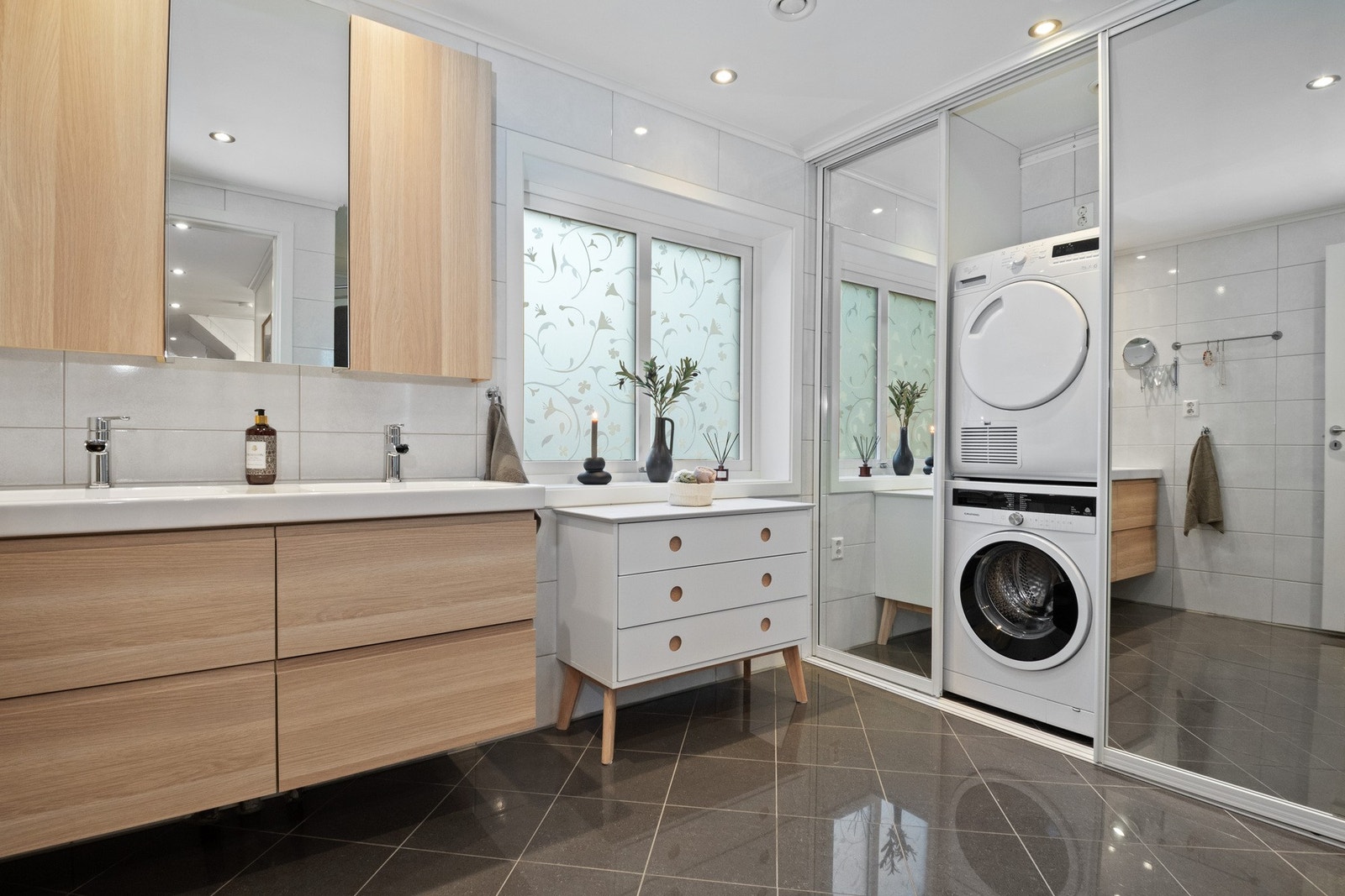 Delikat og romslig baderom med moderne innredning, doble servanter og plass for både vask og tørk. Galleribilde