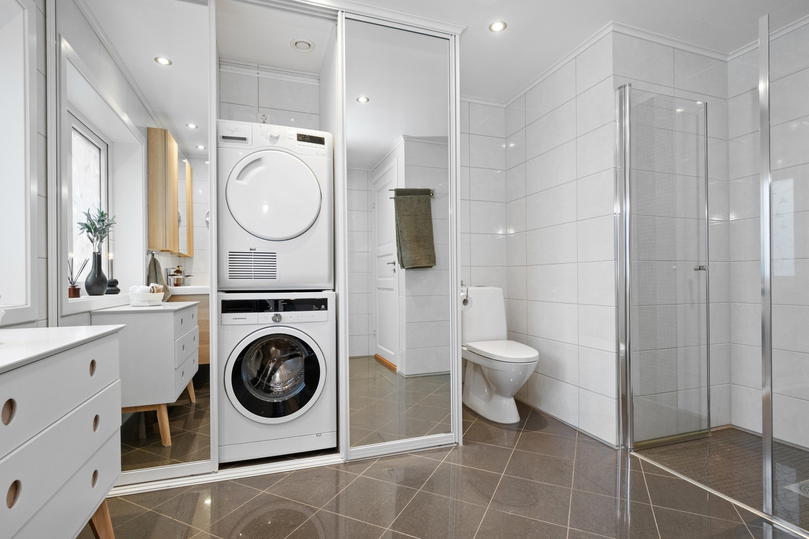 Badet er helfliset og innredet med varme toner og store speilflater som forsterker romfølelsen. Galleribilde