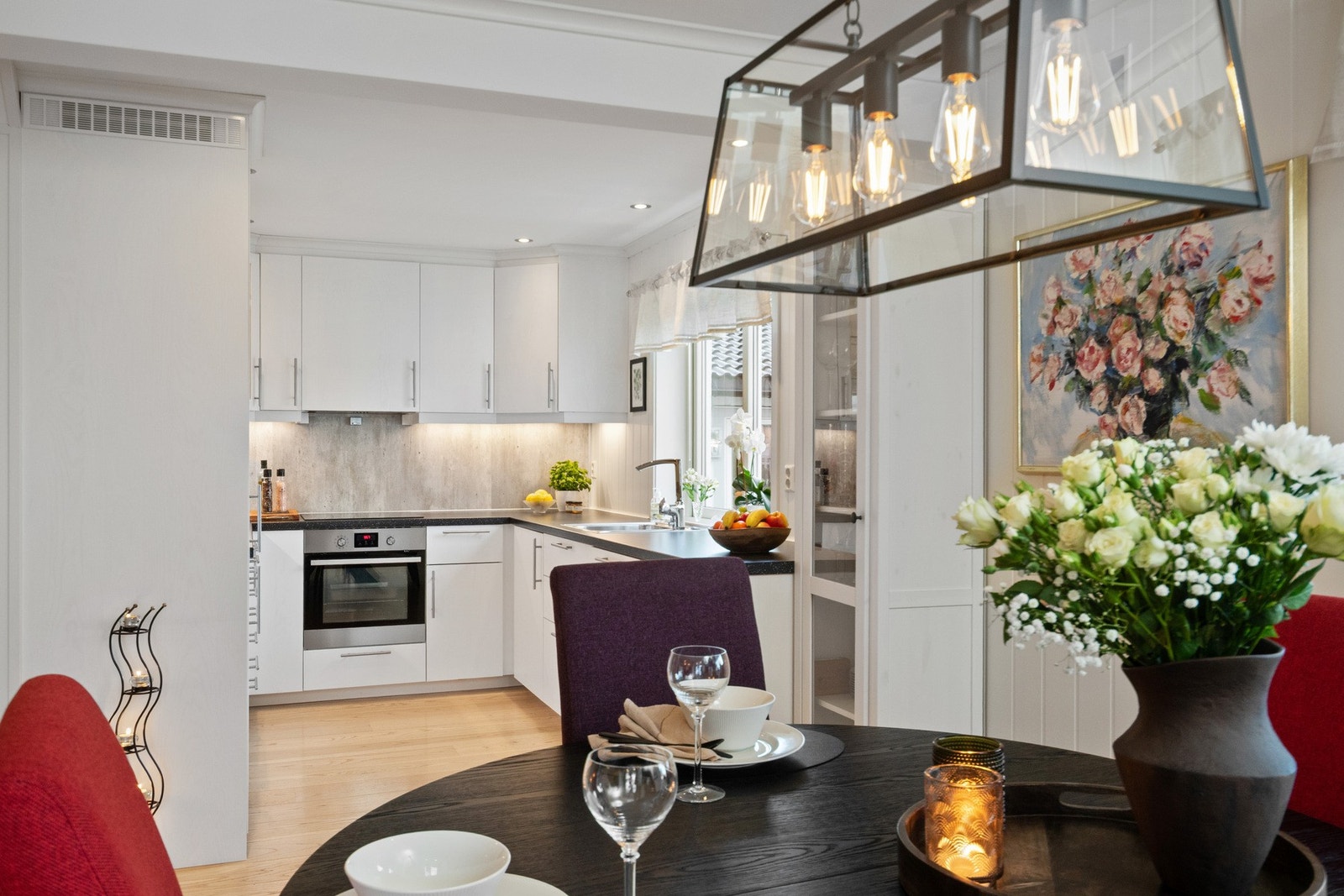 Moderne kjøkken i klassisk hvitt med rene linjer, god benkeplass og integrerte hvitevarer. Galleribilde