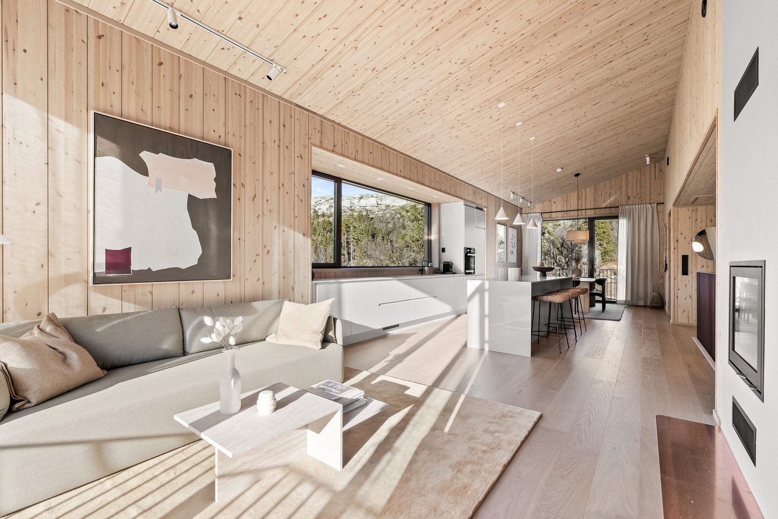 Den åpne løsningen mellom stue og kjøkken gir en sosial sone med plass til både spisegruppe og sittegruppe for familie og venner. Galleribilde