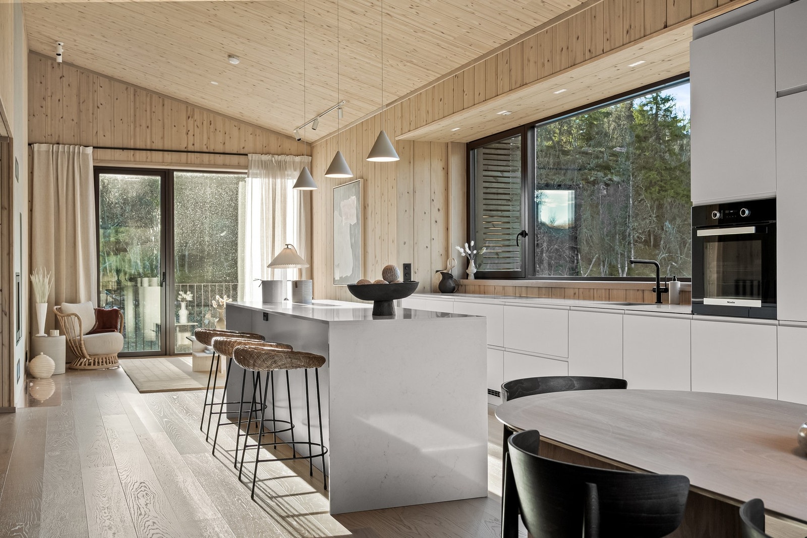 Det er gjennomlys i hele toppetasjen; fra spisestuen på fjellsiden til stue/salongen på dalsiden . Godt hjulpet av et stort liggende vindu ved kjøkkenet. Galleribilde