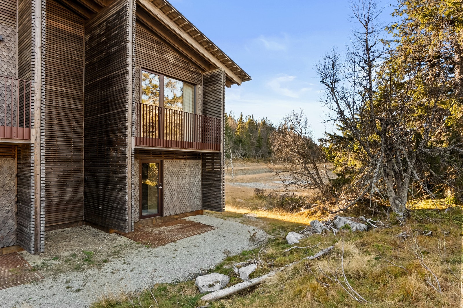 De arkitektonisk markante sideveggene er med på å skape skjermede inngangspartier. Galleribilde