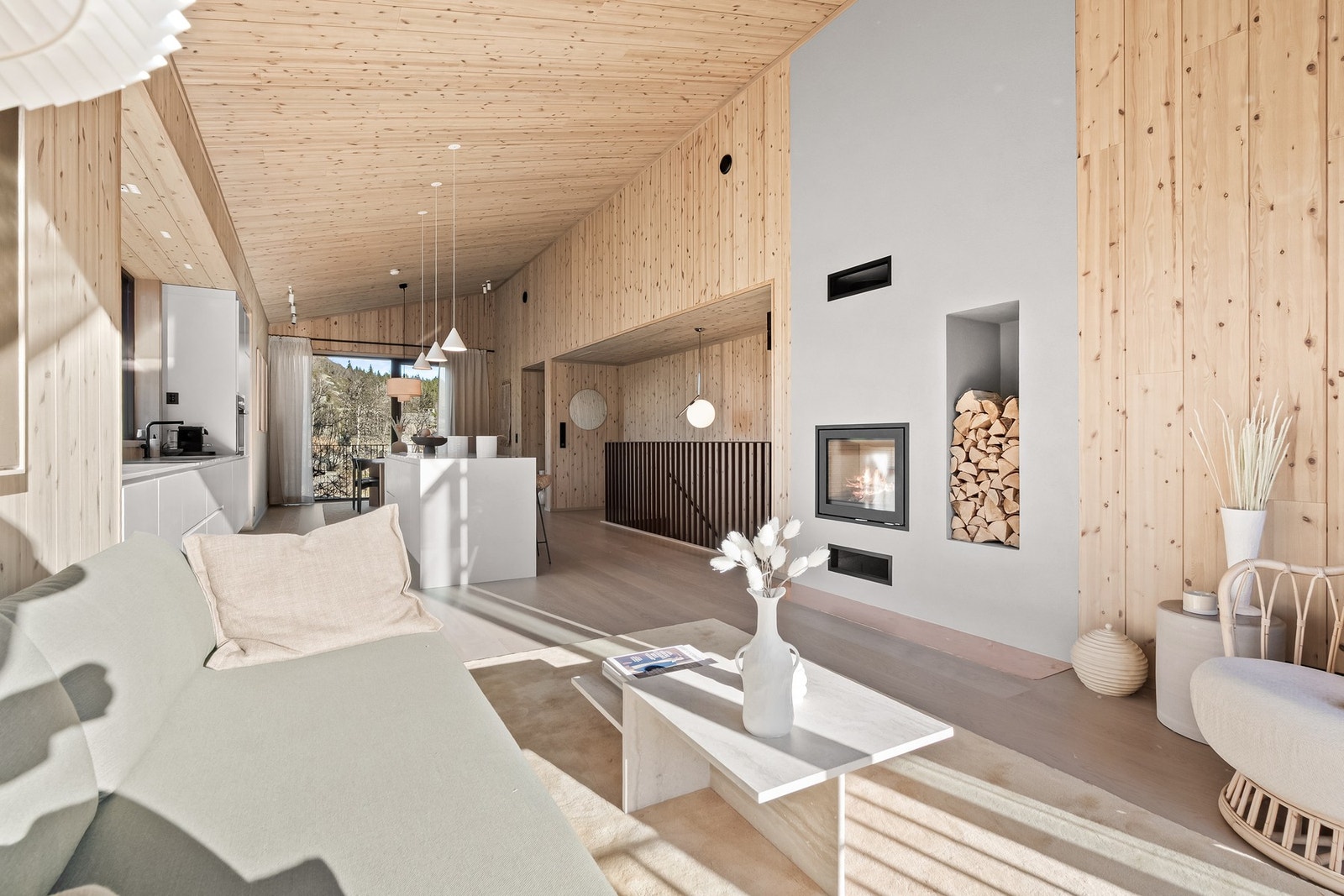 Integrert vedhylle og kobbergnistplate. Peisovnen, og innrammingen av denne, fremstår som et designelement i oppholdssonen. TV-uttak på vegg mellom vedhyllen og terrassedøren. Galleribilde