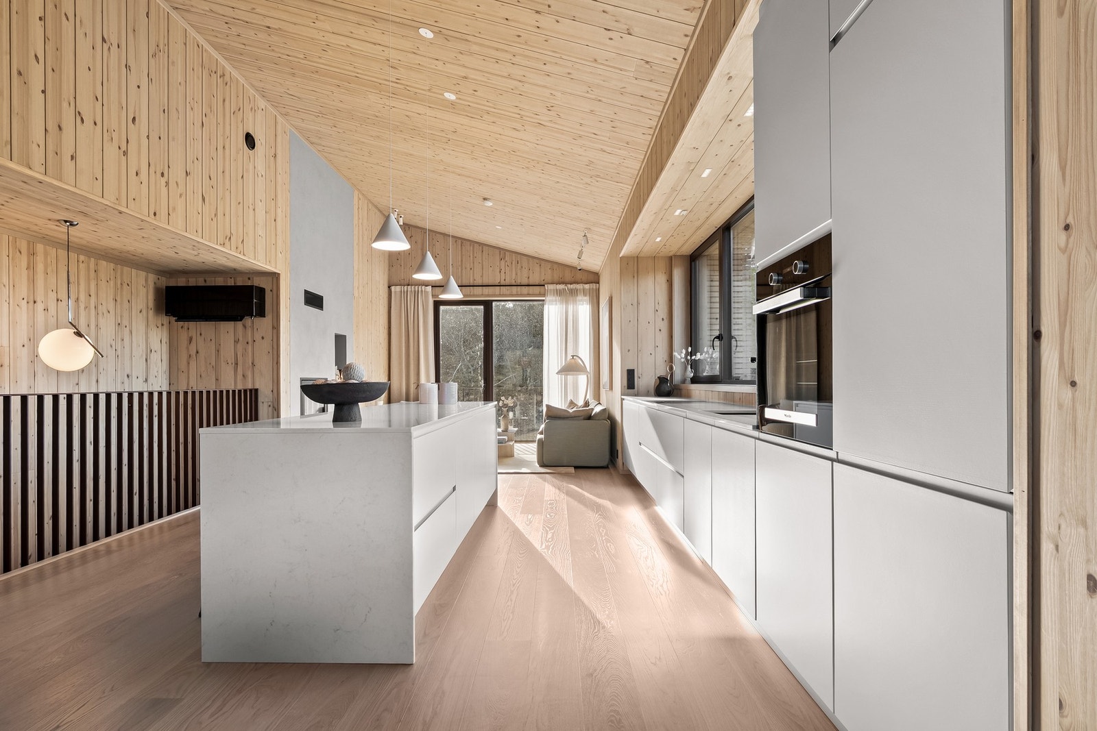 Kjøkkenet ligger sentralt i hyttens sosiale sone med naturlig lys, god plass til spisebord og sømløs overgang til stue. Galleribilde