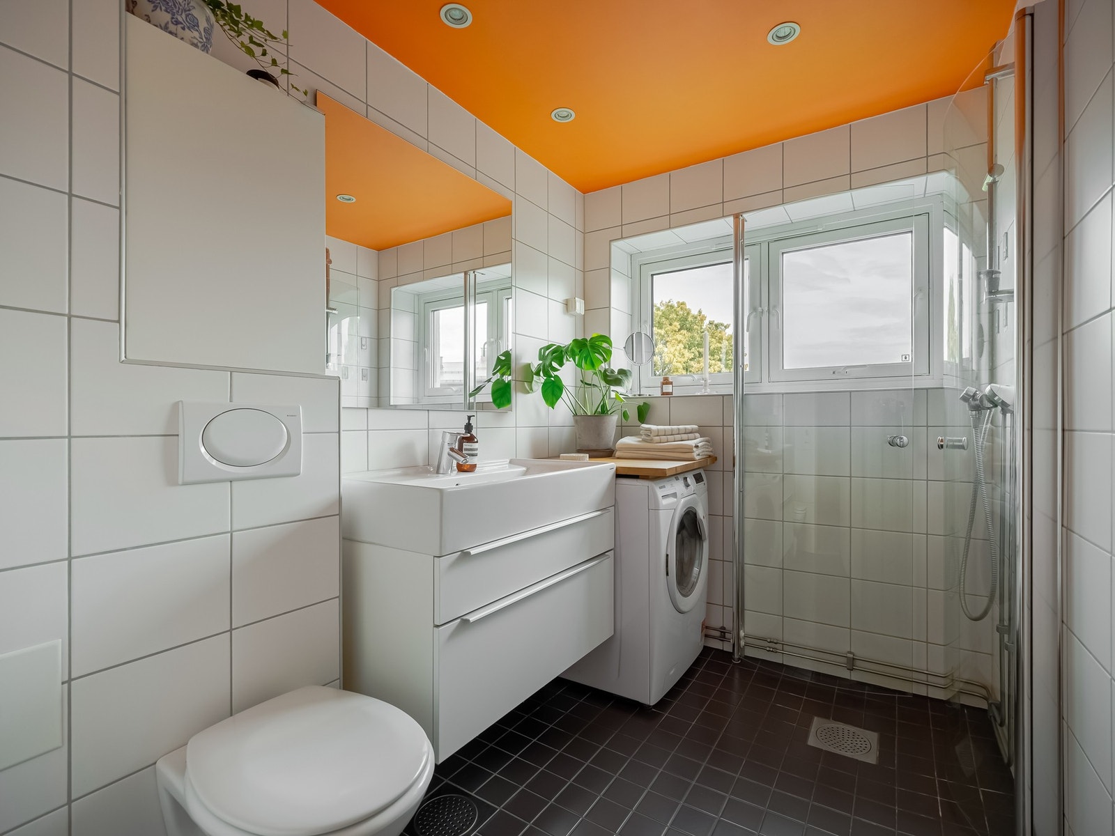 Fra entreen finner vi inngangen til badet. Innredningen består av vegghengt toalett, servant, dusjhjørne og vaskemaskin. Galleribilde