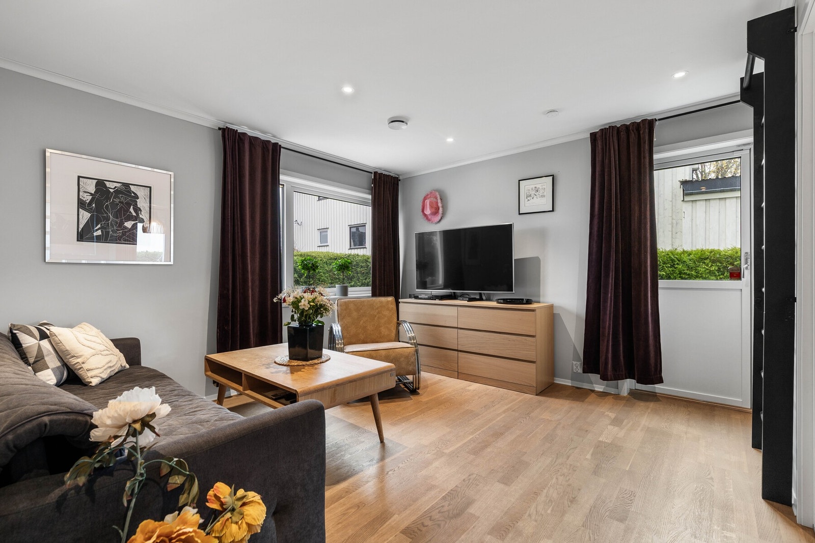 TV-stuen har parkett på gulv og gråmalte vegger. Malt tak i hvitt med downlights. Galleribilde