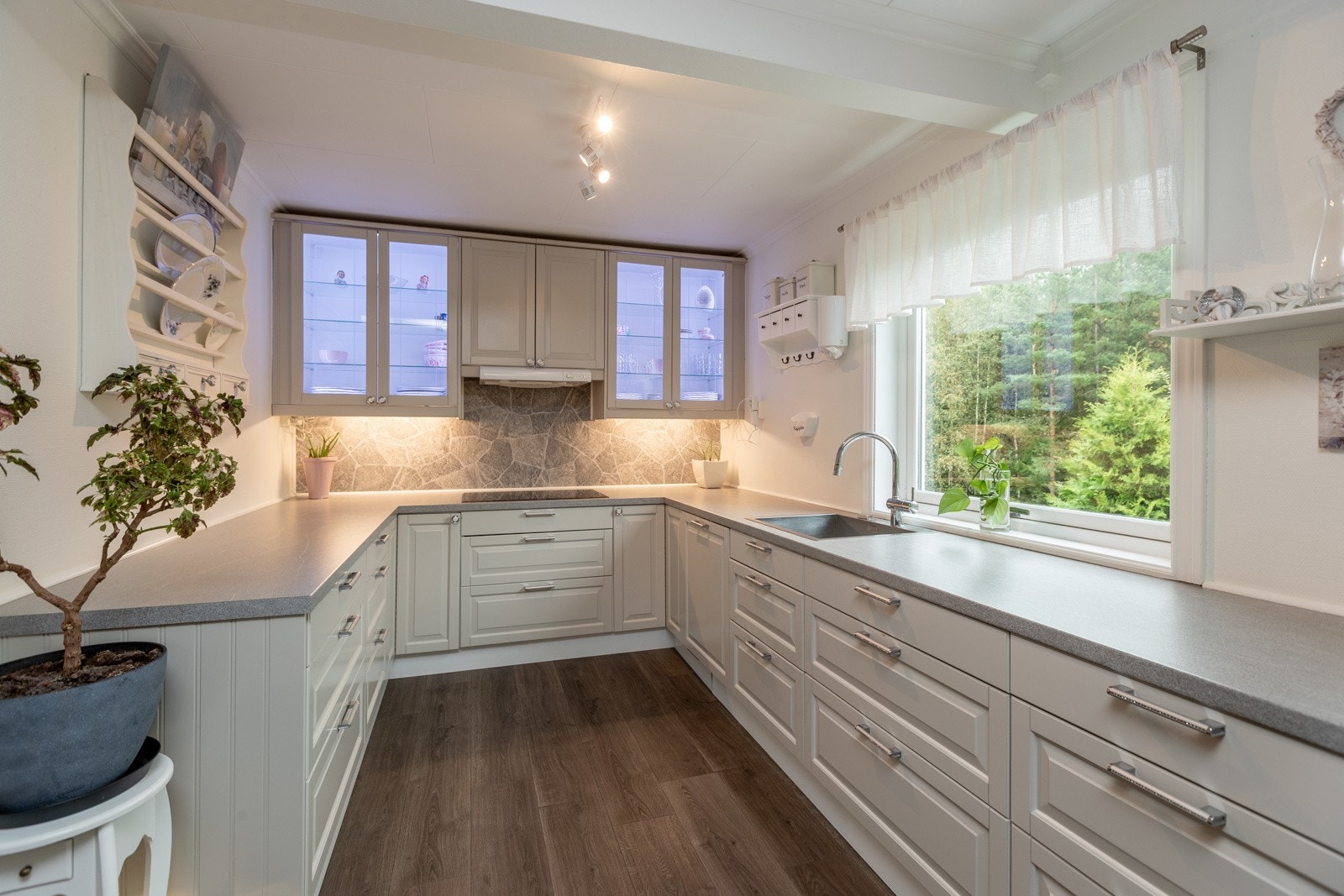 Lys innredning med belysning under overskap og i overskap. Vindu slipper inn dagslys Galleribilde