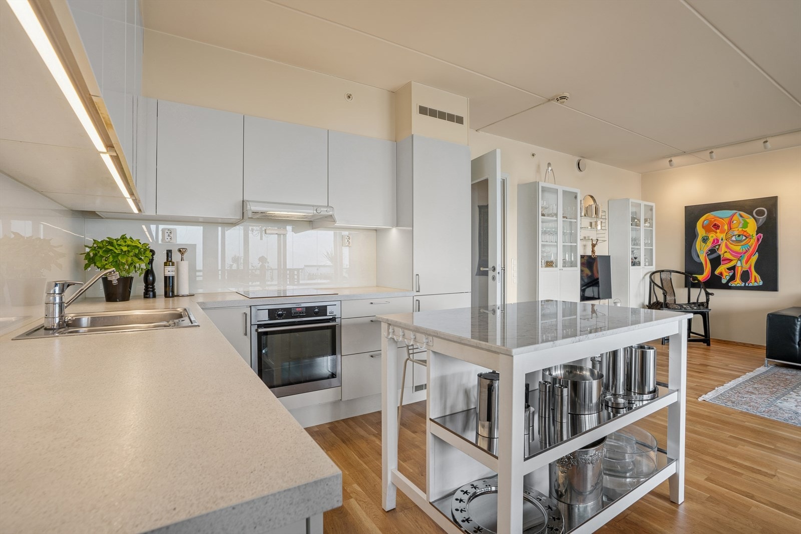 Innredning med hvite slette fronter, laminat benkeplate og utslagsvask med blandebatteri. Galleribilde