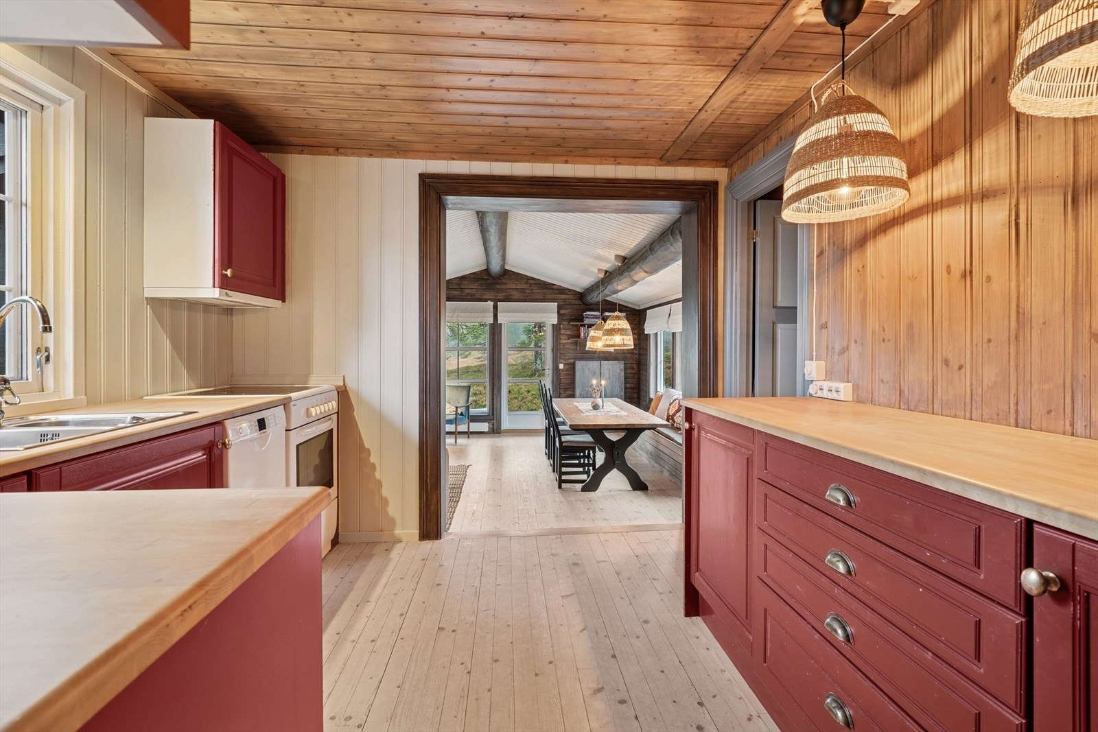 Kjøkkenet er innredet med kjøleskap, oppvaskmaskin og komfyr Galleribilde