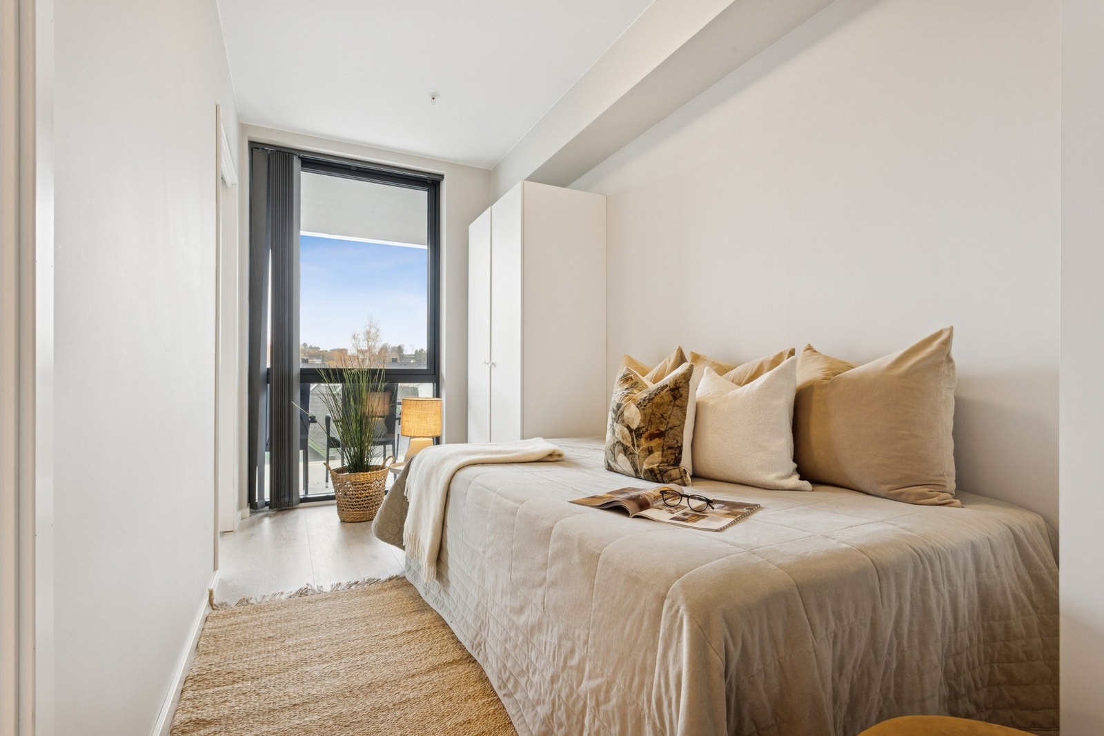 Et lyst soverom som får godt med lysinnslipp fra stort vindu. Galleribilde