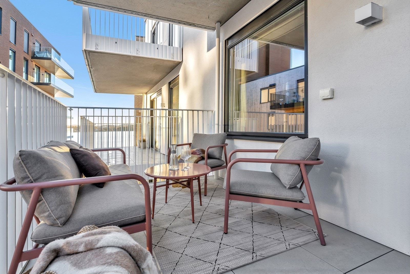 Det flislagte underlaget gir et solid og stilrent preg, og utsikten mot sjøen gir en ekstra dimensjon til uteopplevelsen. Galleribilde