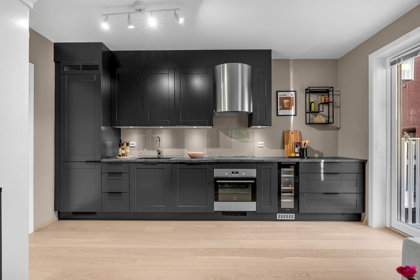 Alle nødvendige hvitevarer er integrert for et sømløst uttrykk, inkludert induksjonstopp, stekeovn, kjøle-/fryseskap, vinskap og oppvaskmaskin - alt lagt til rette for å gjøre hverdagen enkel og behagelig. Galleribilde