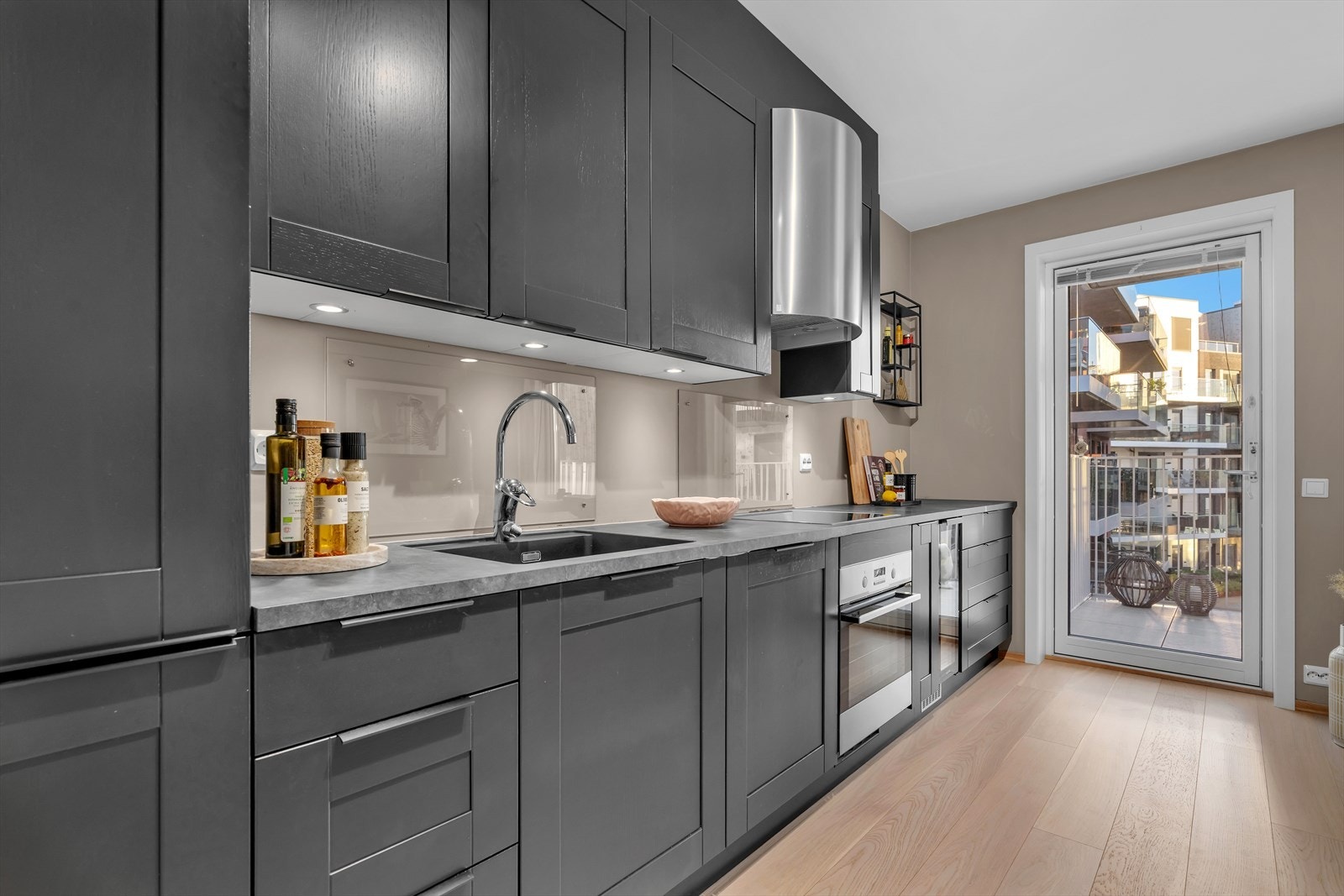 En herdet glassplate bak vask og platetopp sørger for enkel rengjøring samtidig som det tilfører en moderne detalj. Galleribilde