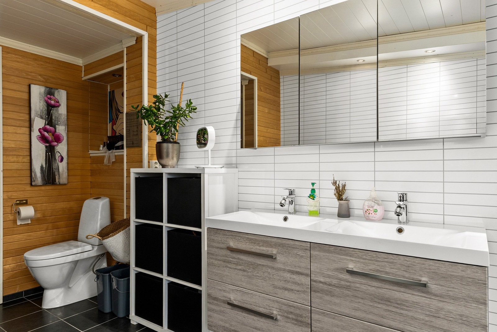 Rommet har innredning med doble servanter, toalett, badekar og dusjhjørne med glassvegger. Galleribilde