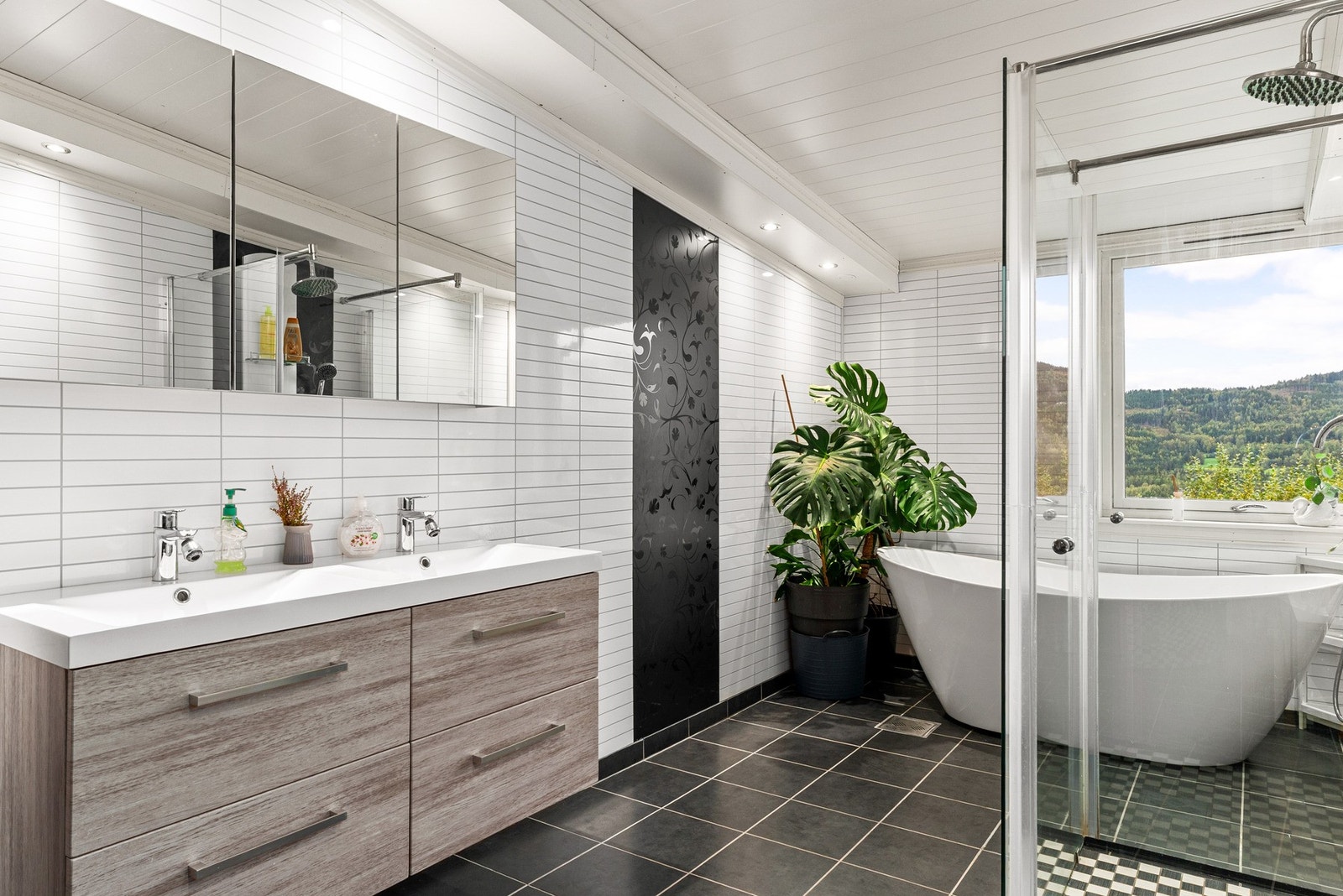 Her er det vegger med baderomsplater, flislagt gulv med elektriske varmekabler og malt tak. Galleribilde