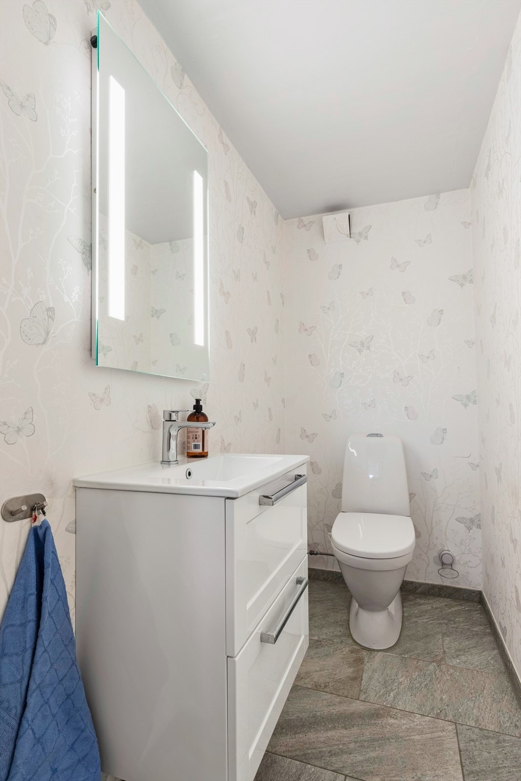 Toalettrom i underetasje, pusset opp i 2018. Fliser på gulv og tapet på vegg. Galleribilde