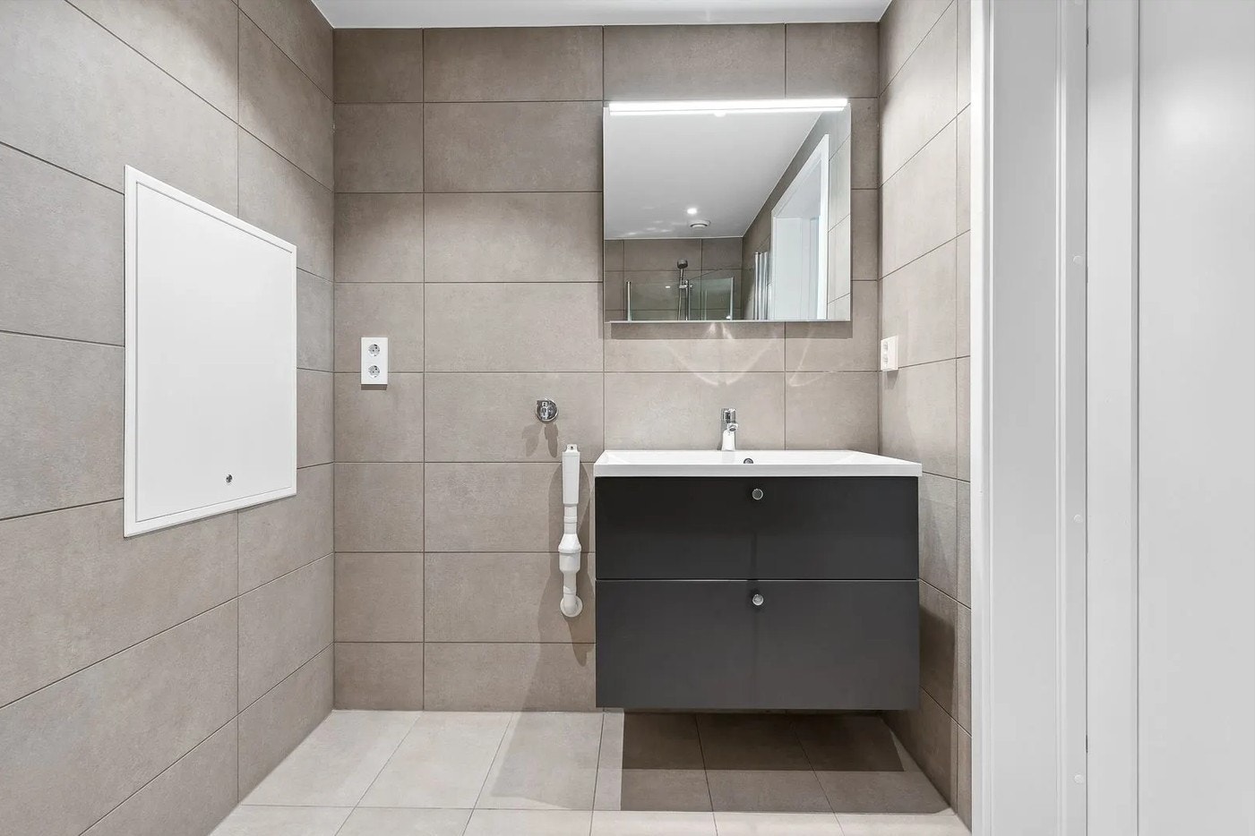 Komplett flislagt bad med Sigdal innredning og opplegg til vaskemaskin. Galleribilde