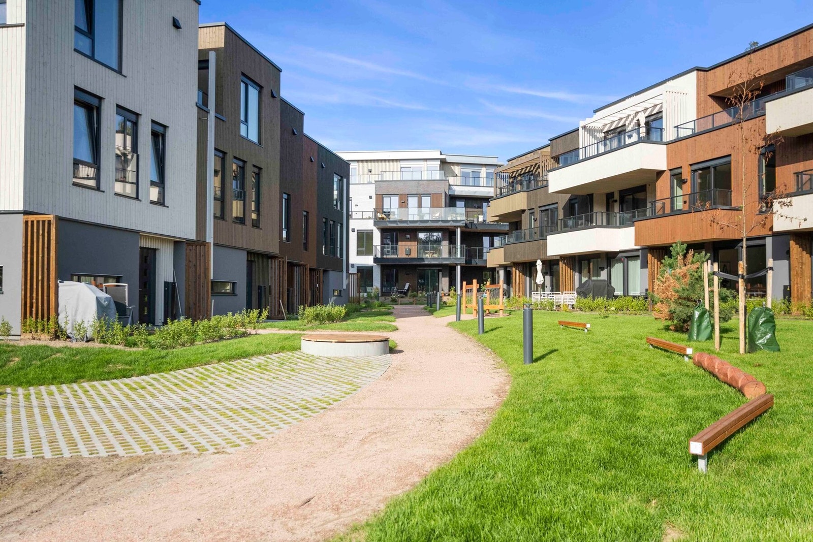 De frodige utendørsområdene er nøye utformet for å skape et visuelt samspill mellom naturlig vegetasjon, komfortable benker og hyggelige møteplasser i gangveiene mellom byggene. Galleribilde