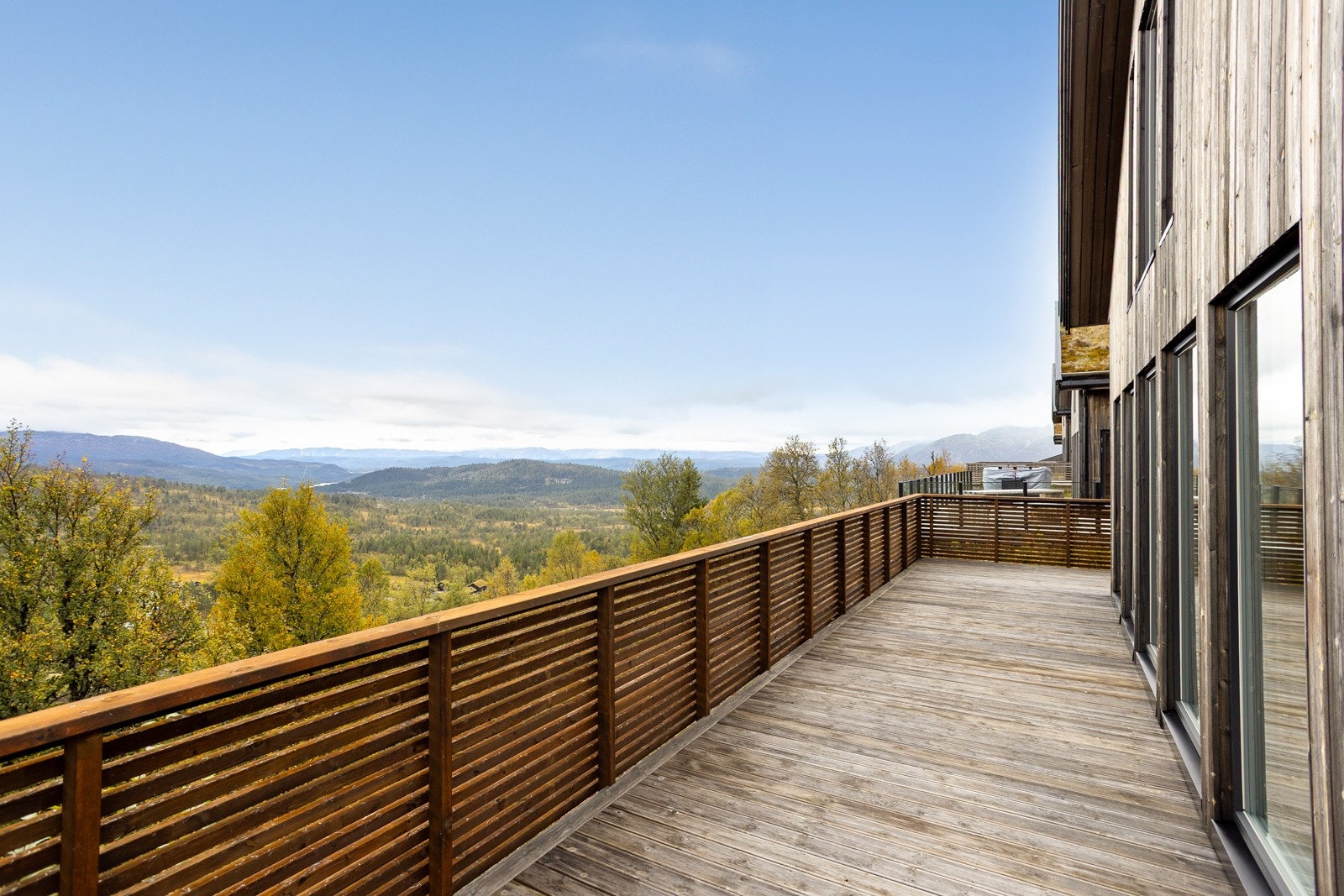 Store vindusflater med spektakulær utsikt og fantastiske solforhold. Rekkverk i Møre Royal. Kledningen på hytta er i eksklusiv Malmfuru Galleribilde