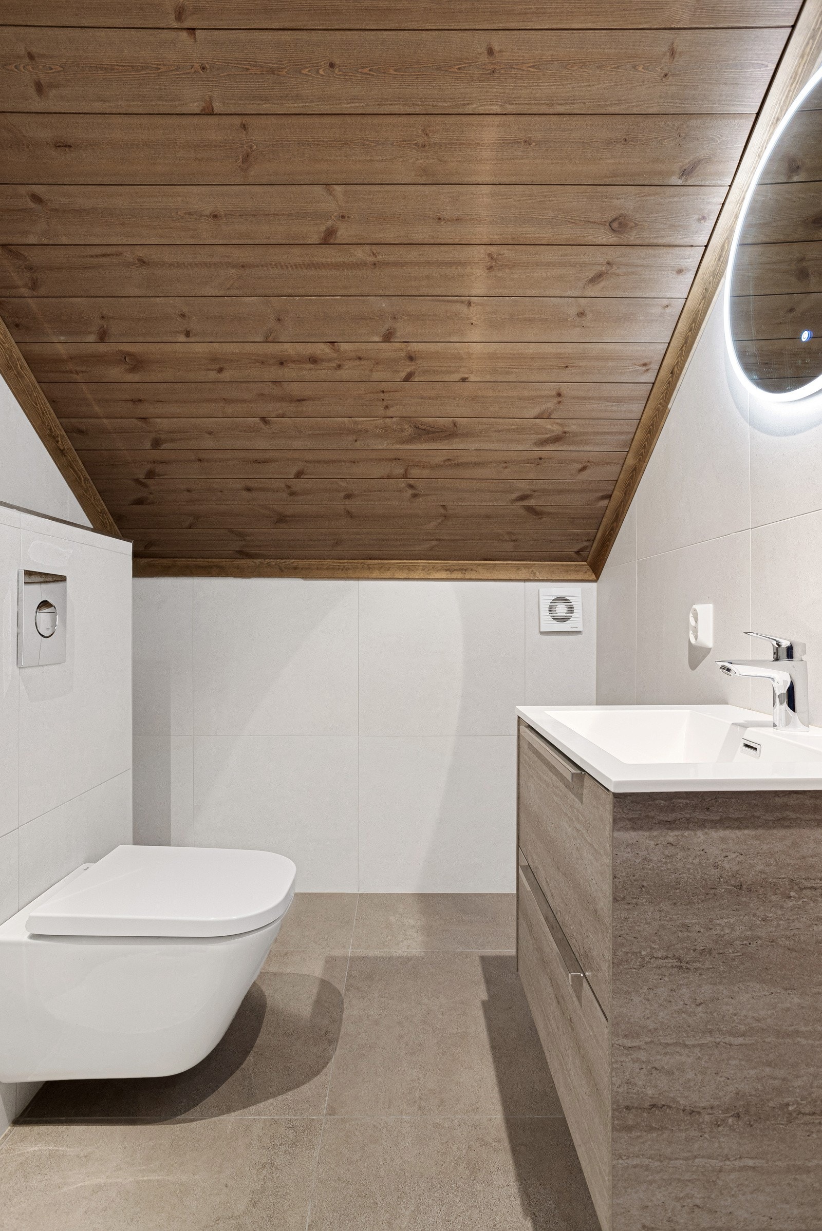 Badet i 2. etasje har store, moderne fliser på vegg og gulv Galleribilde