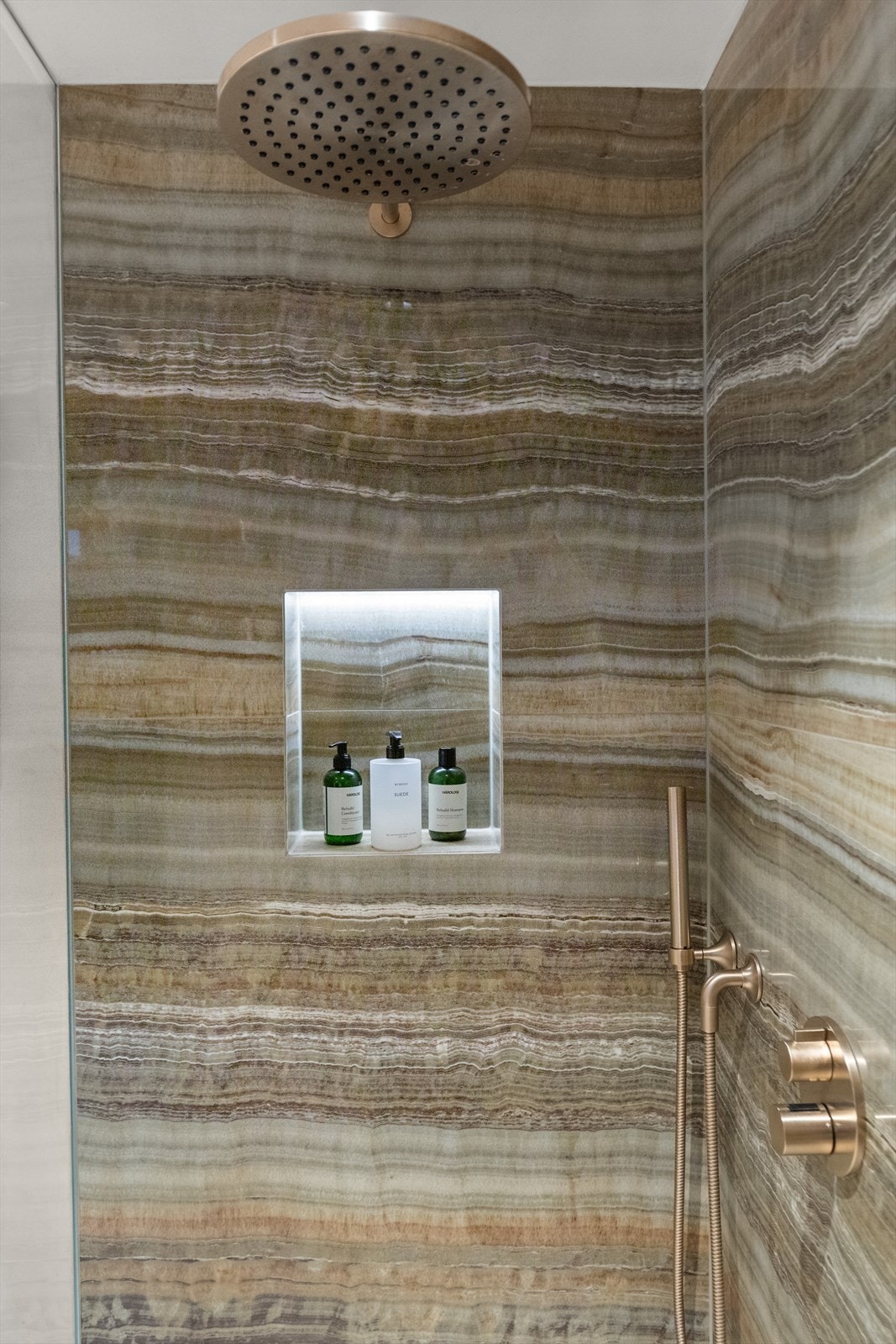 Et stort og eksklusivt bad. Badet er delvis flislagt med påkostede og velvalgte materialer for å skape drømmebadet. Her har du stor dusjnisje med innebygget armatur, hyller, lekker flislagt servant med speil og vegghengt wc. Galleribilde