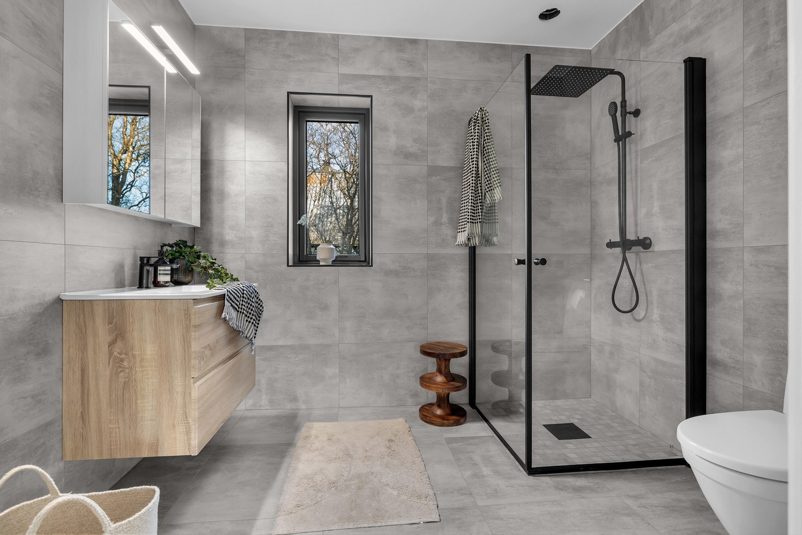 Lekkert flislagt bad med moderne innredning.