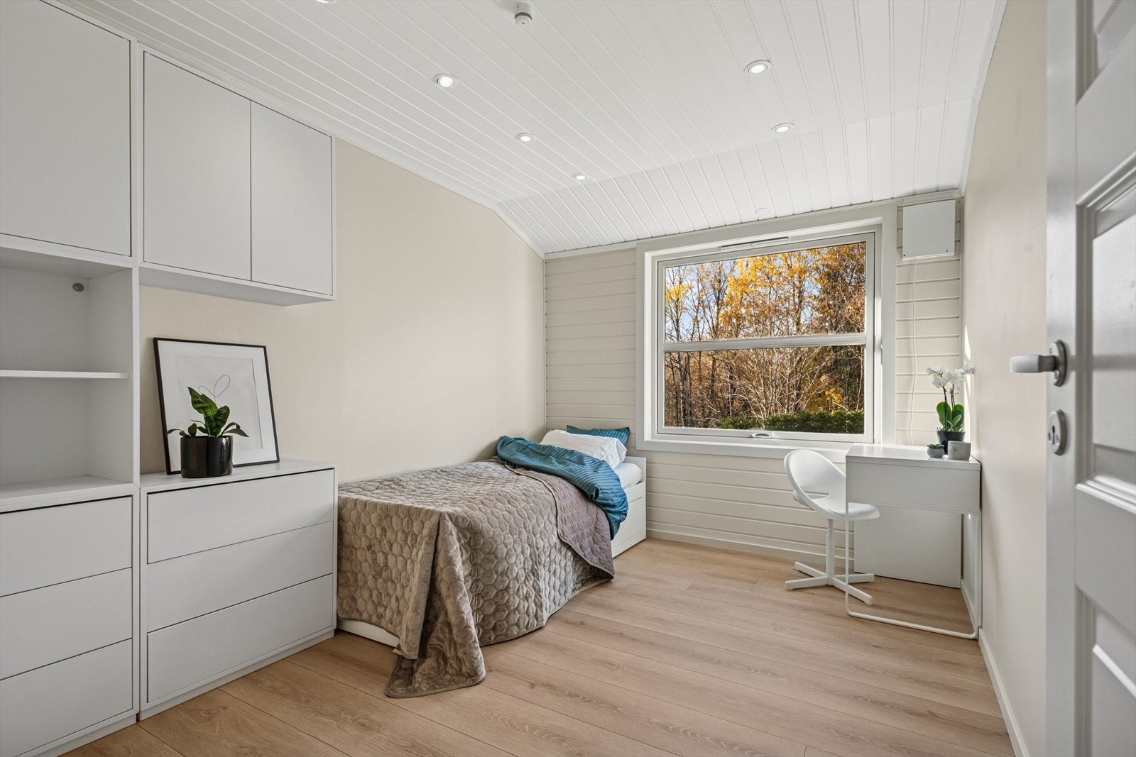 Soverom med lyse overflater og god plass til seng, skrivepult og oppbevaring Galleribilde