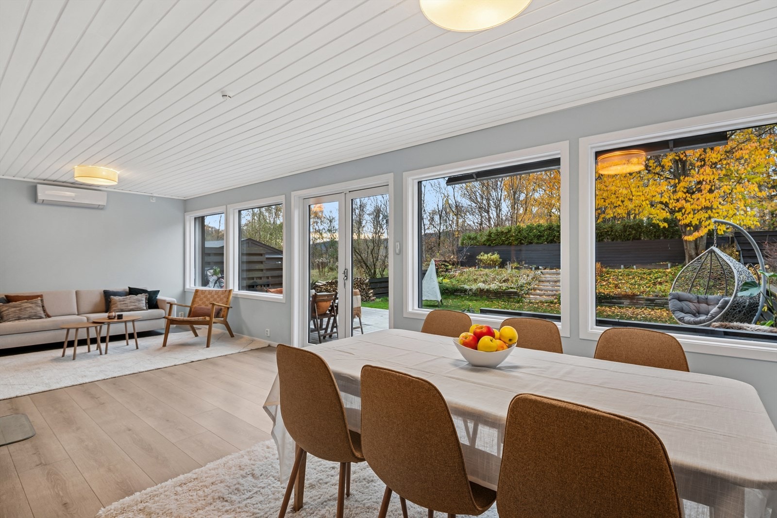 Lys og luftig stue med store vinduer og en sømløs overgang mellom inne- og uterom - perfekt for lange sommerkvelder Galleribilde