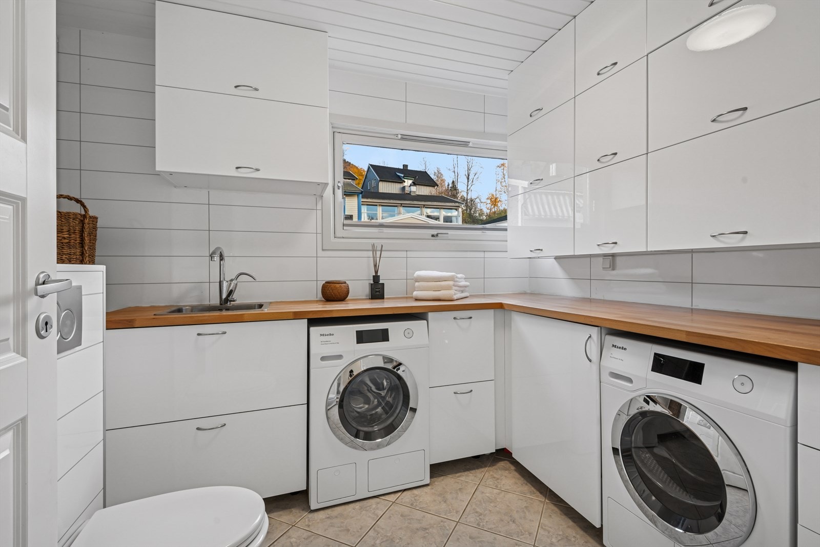 Kombinert vaskerom og toalett med enkel adkomst fra entré - ideelt for familieliv og hverdagslogistikk Galleribilde