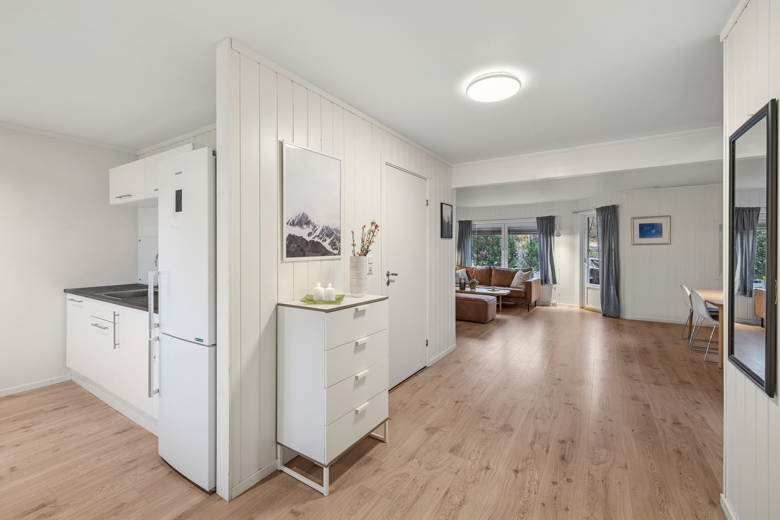 Kjøkkenet ligger i en delvis åpen og sosial løsning mot stuen og spisesonen, noe som skaper en naturlig flyt mellom matlaging og måltider. Galleribilde