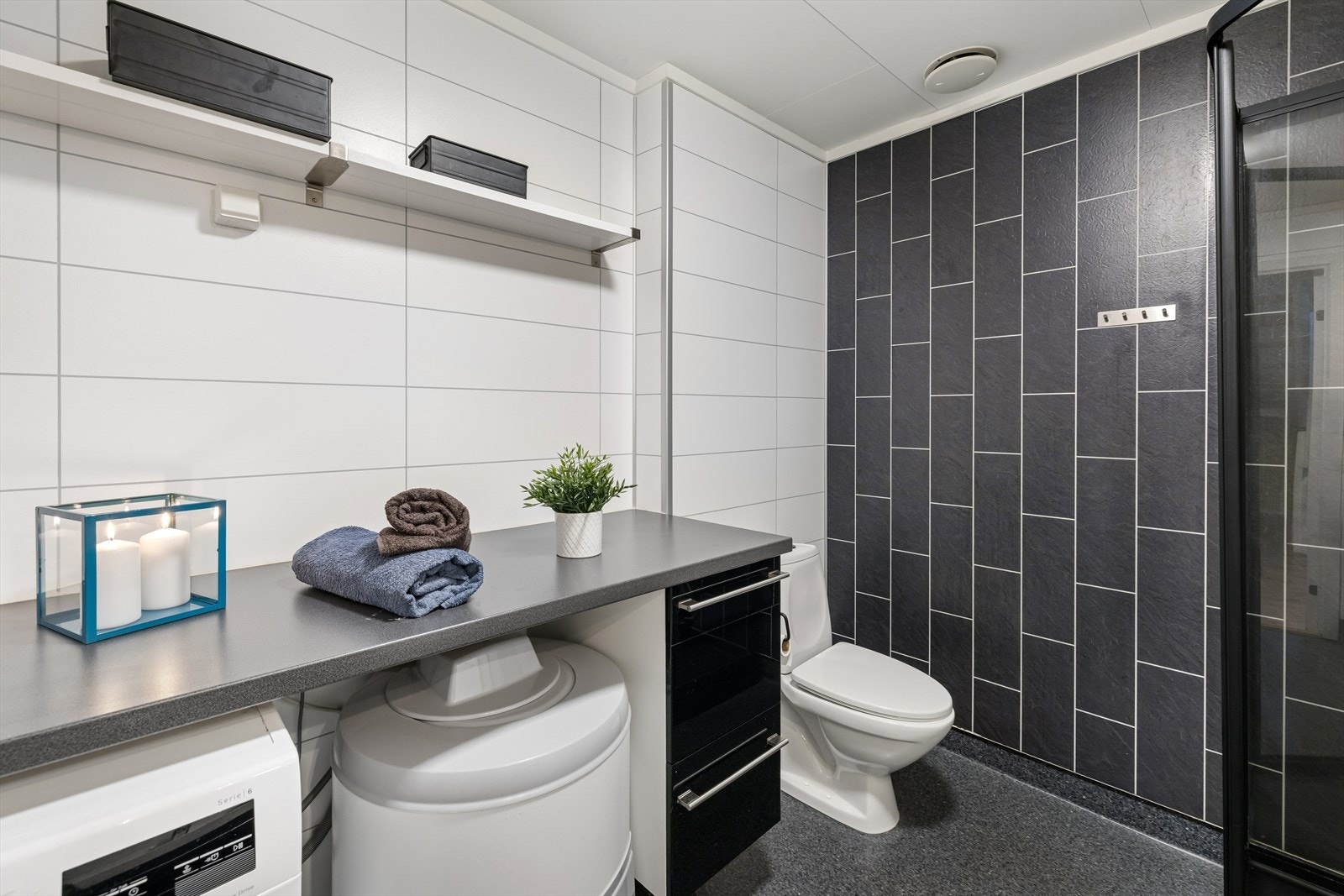 Badet er innredet med servant, høyskap, speil med belysning, toalett, dusjkabinett av nyere dato og opplegg for vaskemaskin. Galleribilde