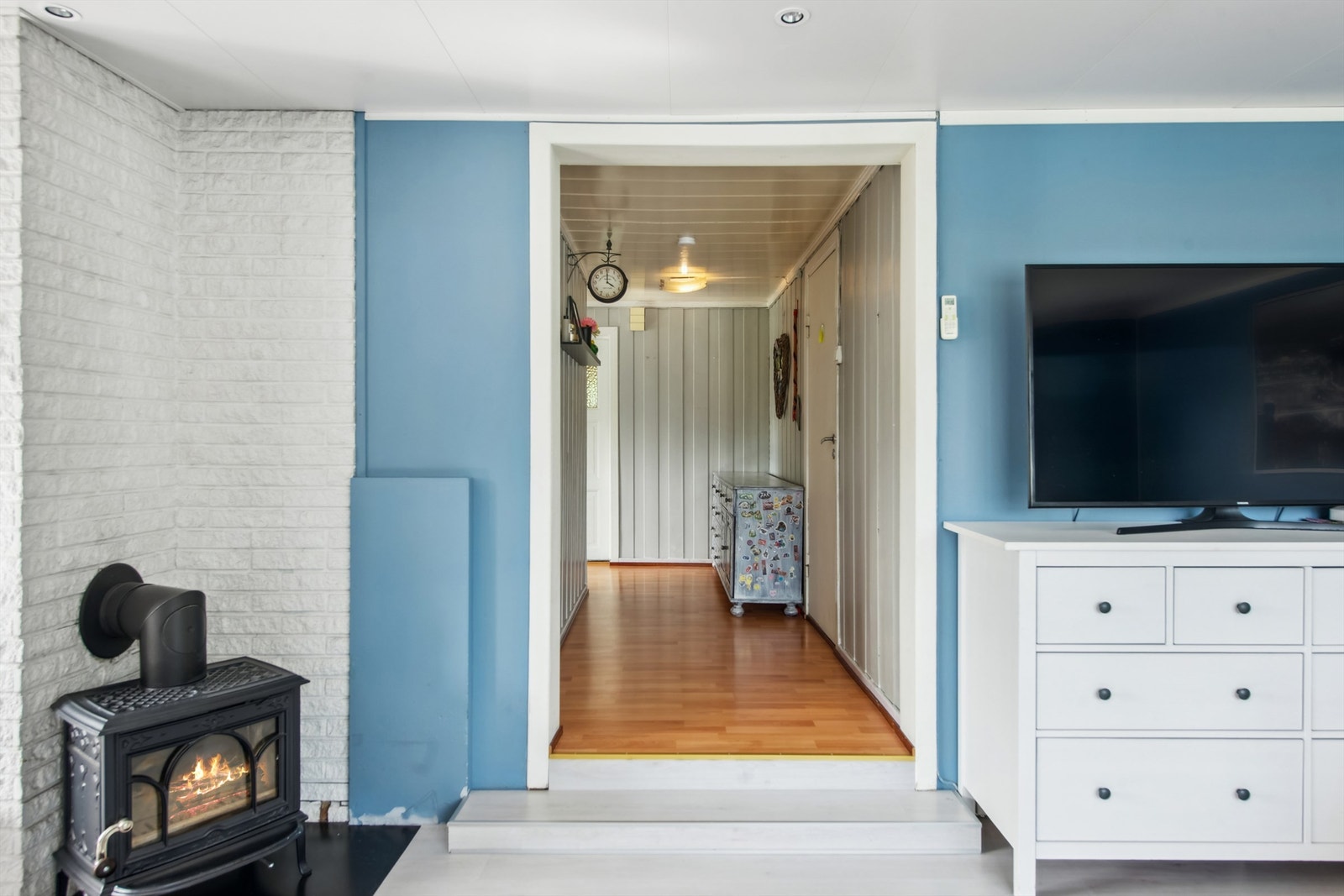 Stuen er utstyrt med en av boligens to ildsteder, samt en luft-til-luft-varmepumpe for effektiv oppvarming. Galleribilde