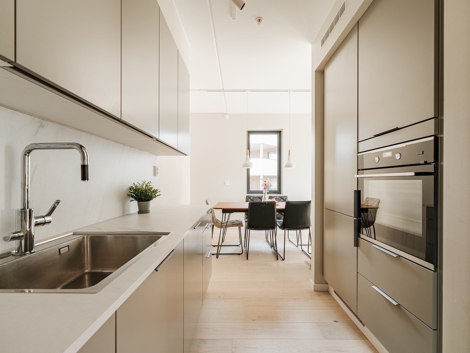 Benkeplaten i lys laminat har nedfelt stålkum med ettgreps armatur i krom og uttrekkbar tut. Galleribilde