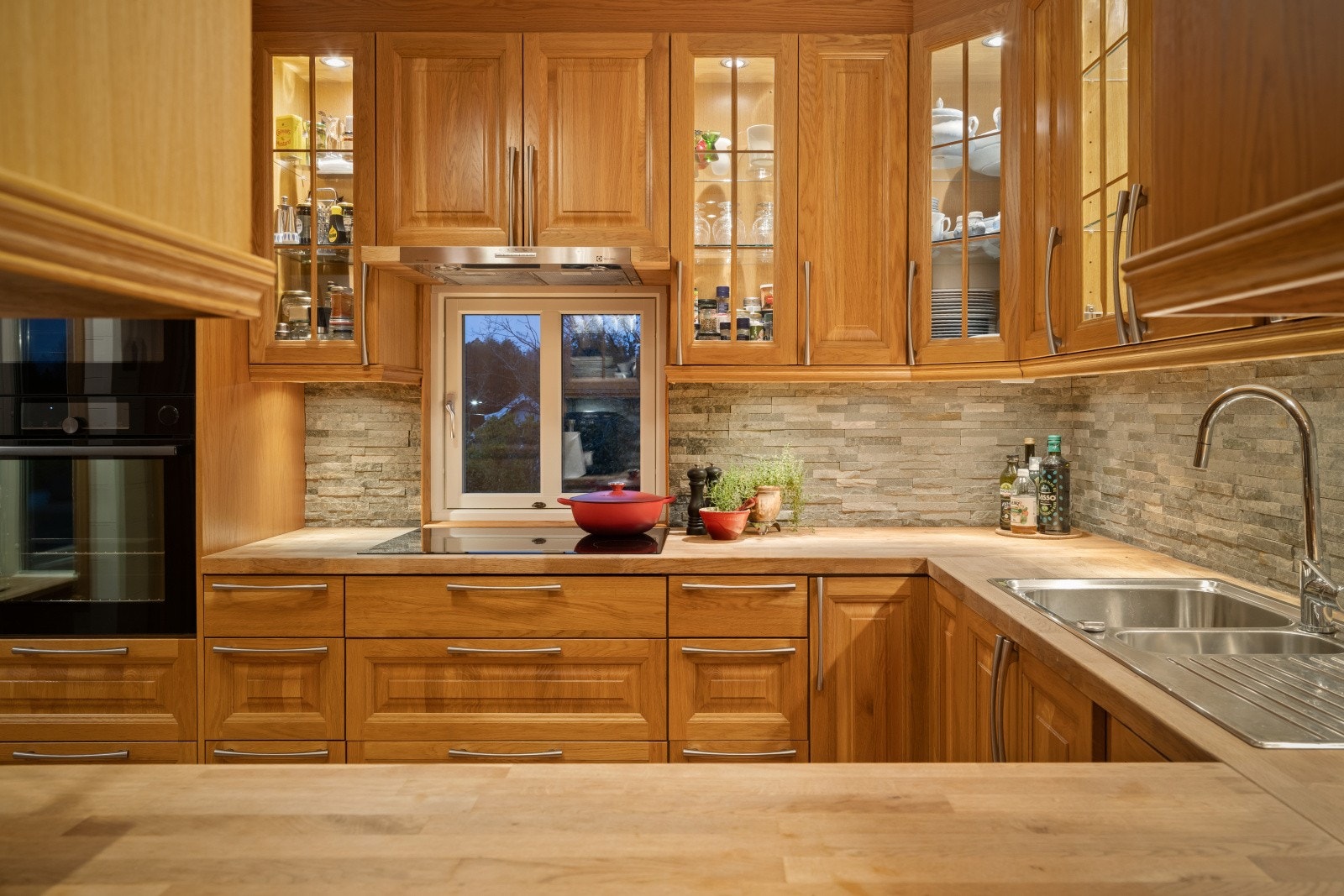 Her er det godt med skapplass og integrerte hvitevarer som gjør matlagingen til en glede. Legg merke til kombinasjonen av naturmaterialer på kjøkkenet. Galleribilde