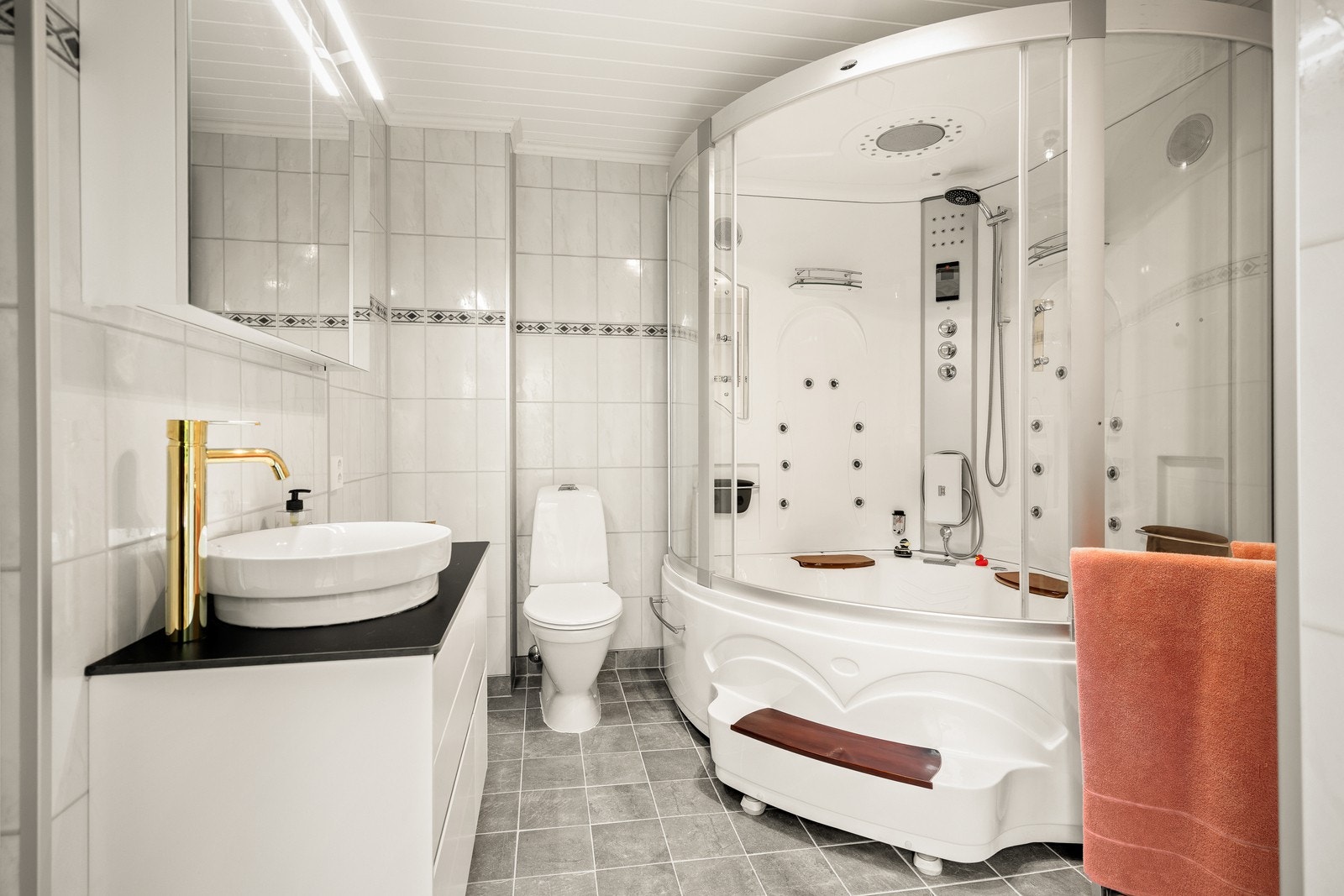 Vaskerommet er praktisk innredet med baderomsplater på veggene og panel i taket, noe som gir et rent og innbydende uttrykk. Gulvet er flislagt og har elektriske varmekabler. Se pkt. ferdigattest. Galleribilde