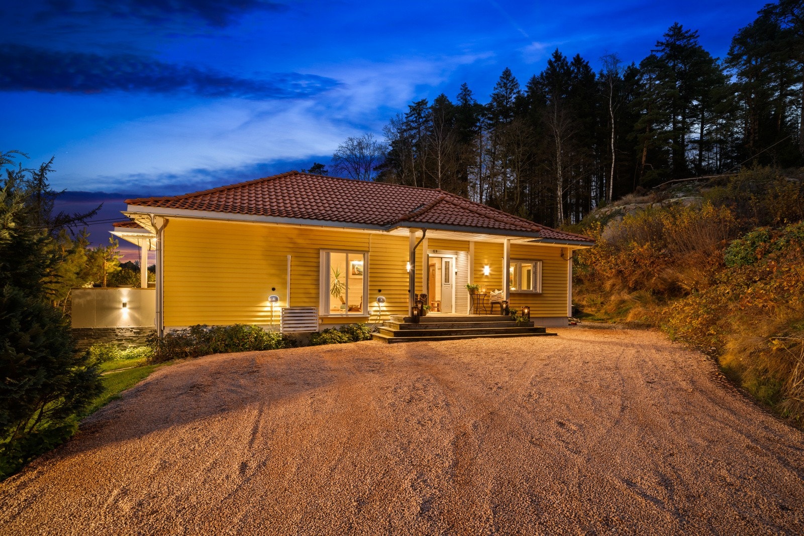 Eiendommen har stor, gruset gårdsplass med mulighet til å kjøre helt til døren. Her er det også montert to elbil-ladere. Galleribilde