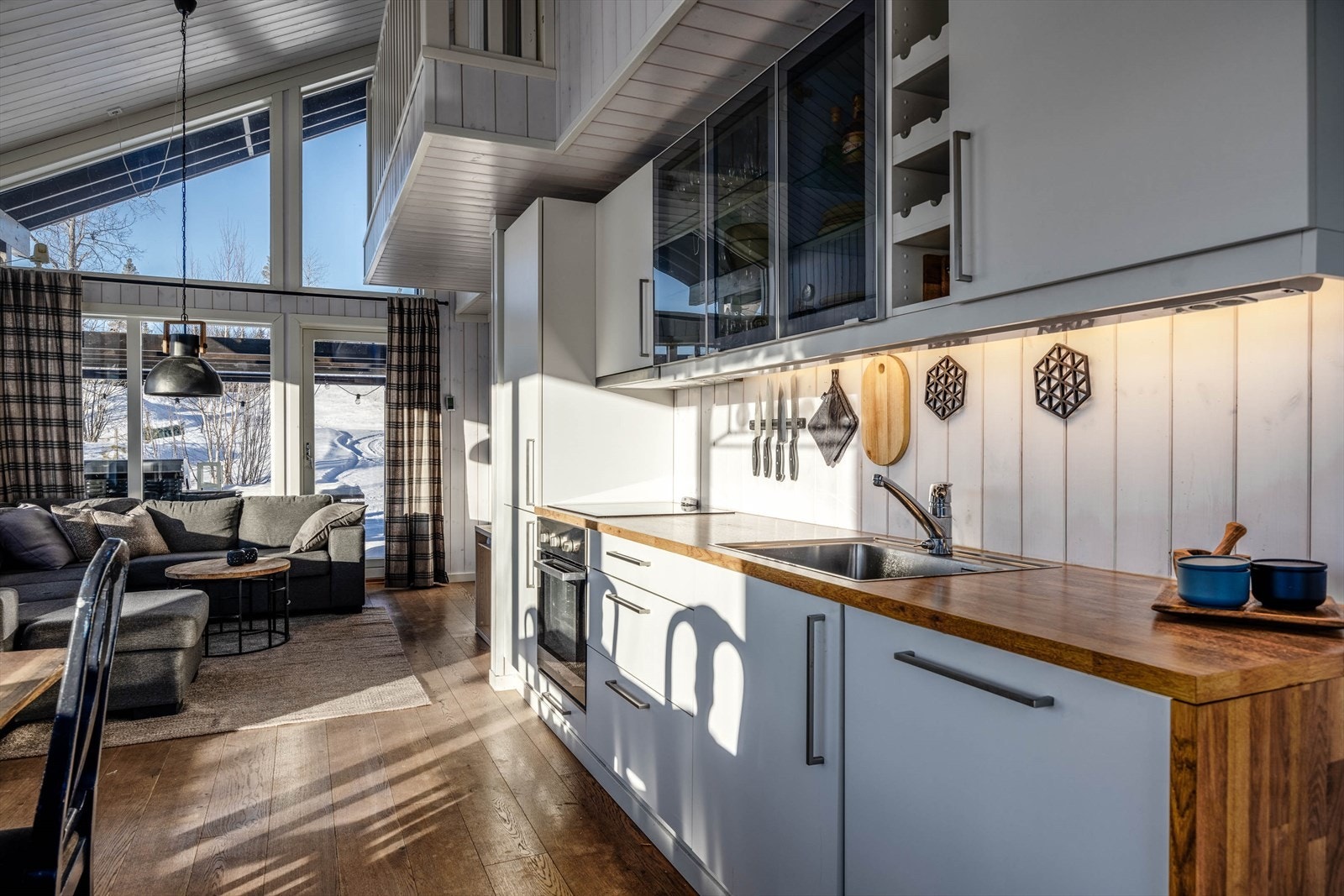 Lys og innbydende stue/åpen kjøkkenløsning med store vindusflater som slipper inn naturlig lys, og skaper en varm atmosfære. Galleribilde