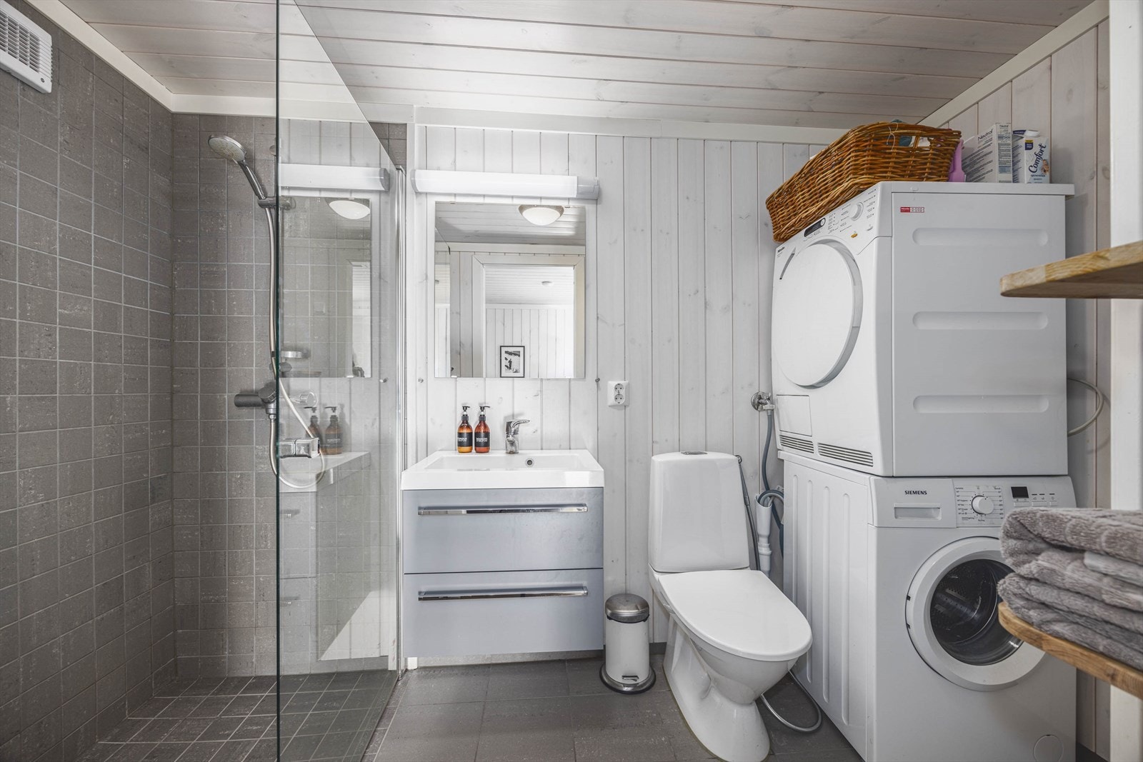 Moderne baderom med praktisk vaskesøyle og dusjnisje. Lys og stilren innredning gir en behagelig atmosfære. Galleribilde