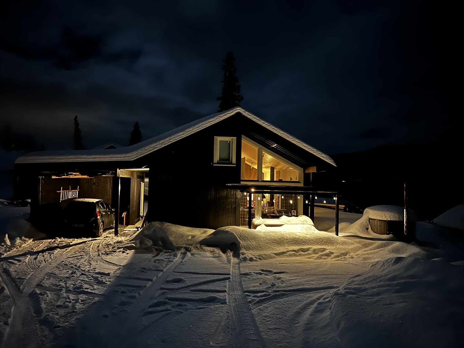 Koselig hytte i vinterlandskap, opplyst i nattemørket. Perfekt beliggenhet for rolige kvelder med nærhet til naturen. Galleribilde
