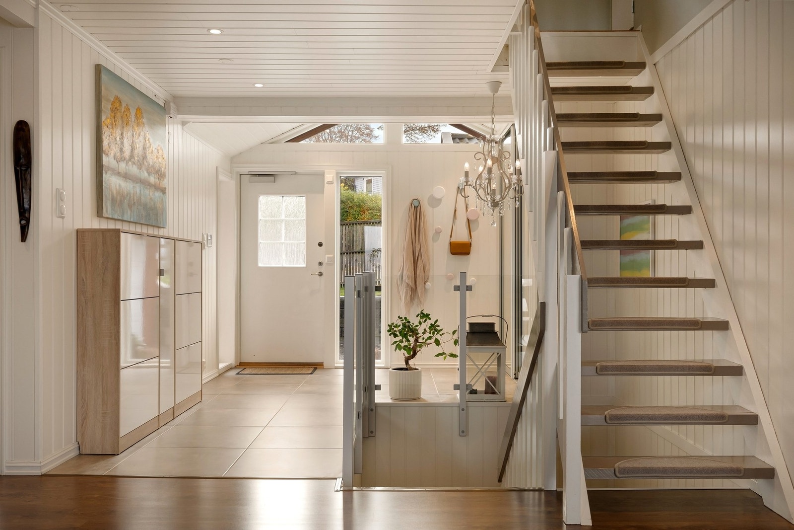 Et åpent og luftig førsteinntrykk! Hallen binder etasjene sammen og har varmekabler i den ytterste delen av flislagt del i vindfanget Galleribilde