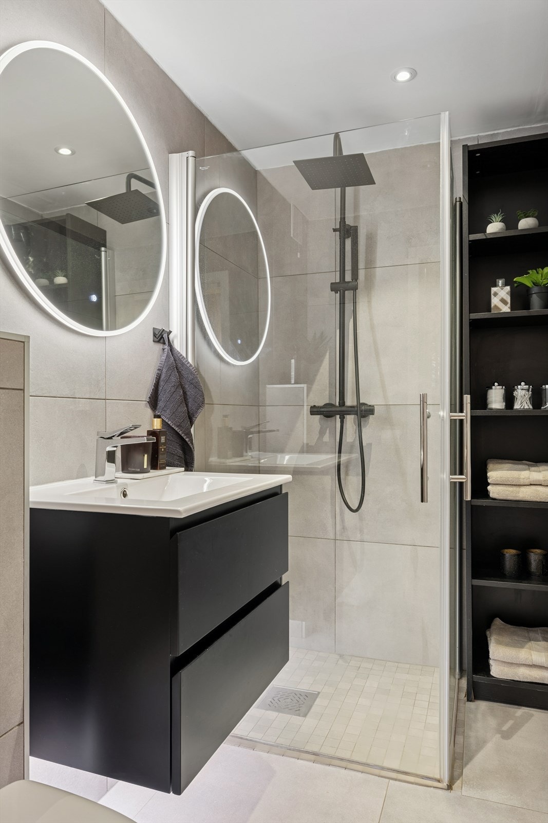 Rommet er innredet med servantinnredning med nedfelt servant, veggmontert toalett og dusjhjørne med glassvegger. Galleribilde