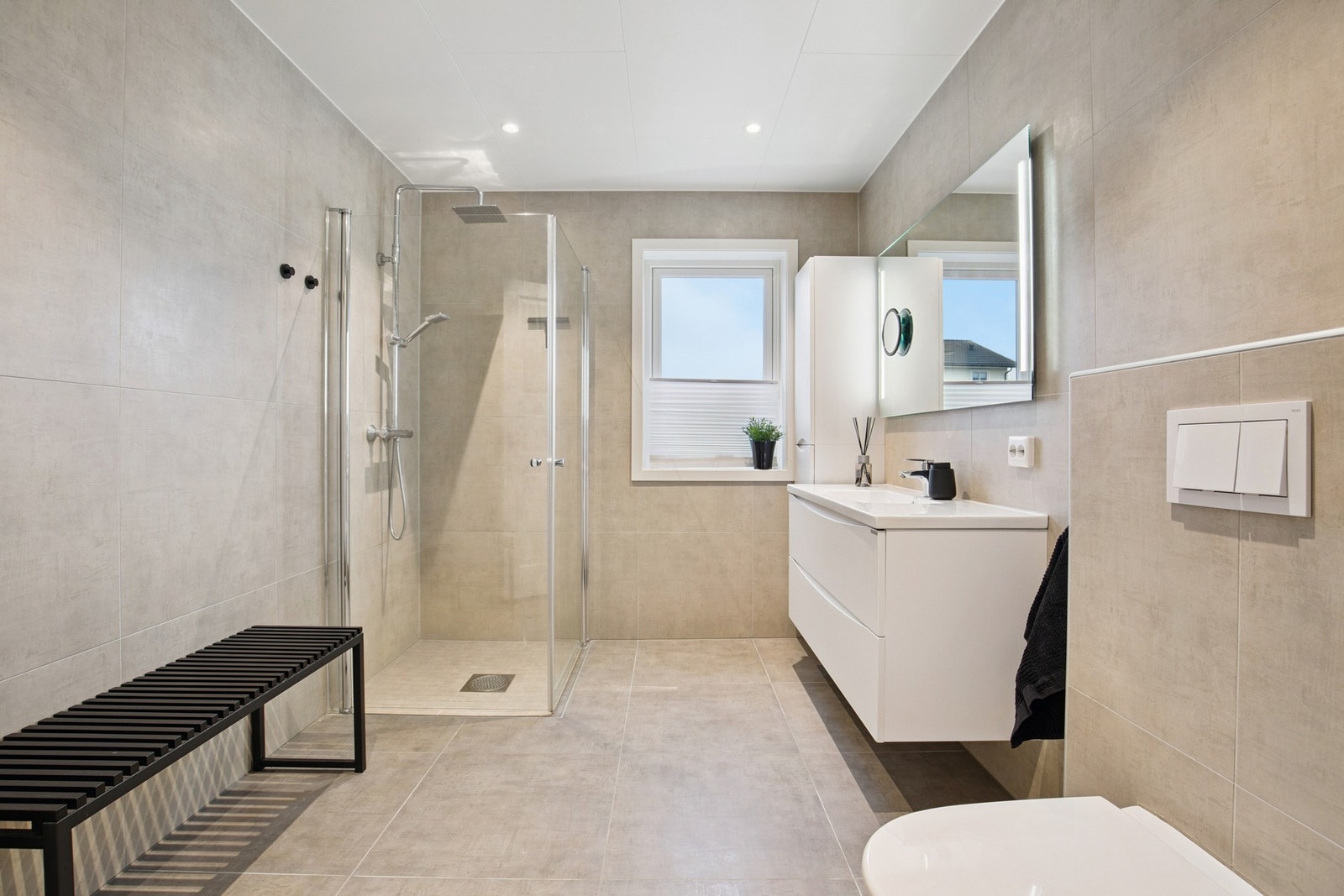 Flislagt bad m/varme i gulv, innredning m/nedfelt servant, dusjnisje og vegghengt wc. Galleribilde