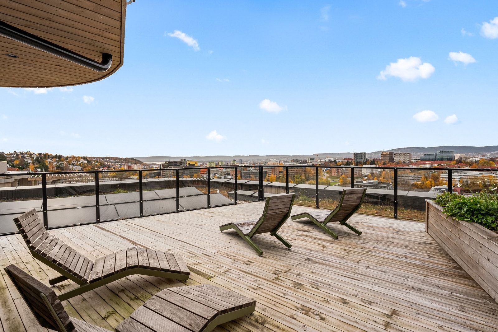 Takterrassene byr på flere koselige soner med sittegrupper, grill og frodig beplantning - perfekt for avslapning og sosiale sammenkomster. Galleribilde