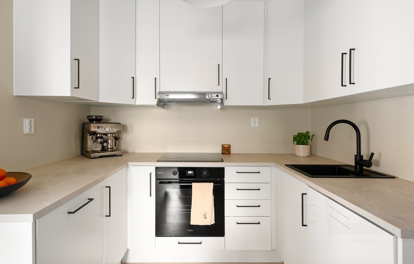 Innredet med glatte fronter, benkeplate fra 2023, integrerte hvitevarer og opplegg for oppvaskmaskin Galleribilde