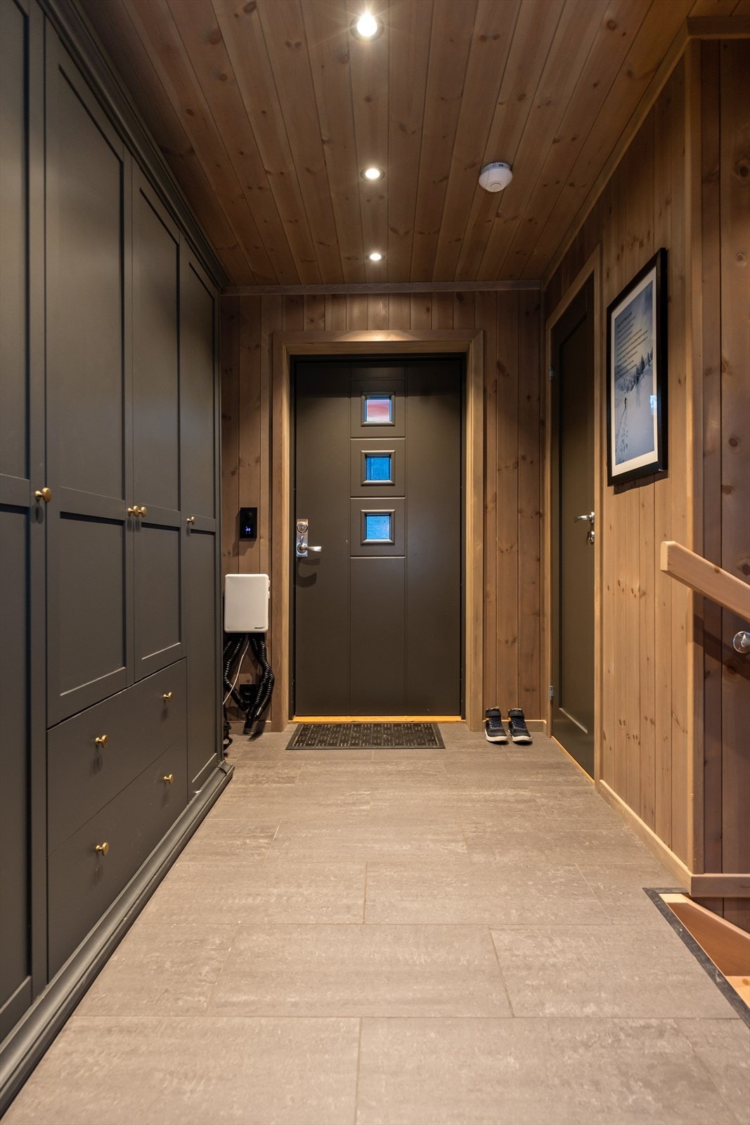 Gang med plass til garderobeskap for oppbevaring av yttertøy og sko. Flis på gulvet med varmekabler. Galleribilde